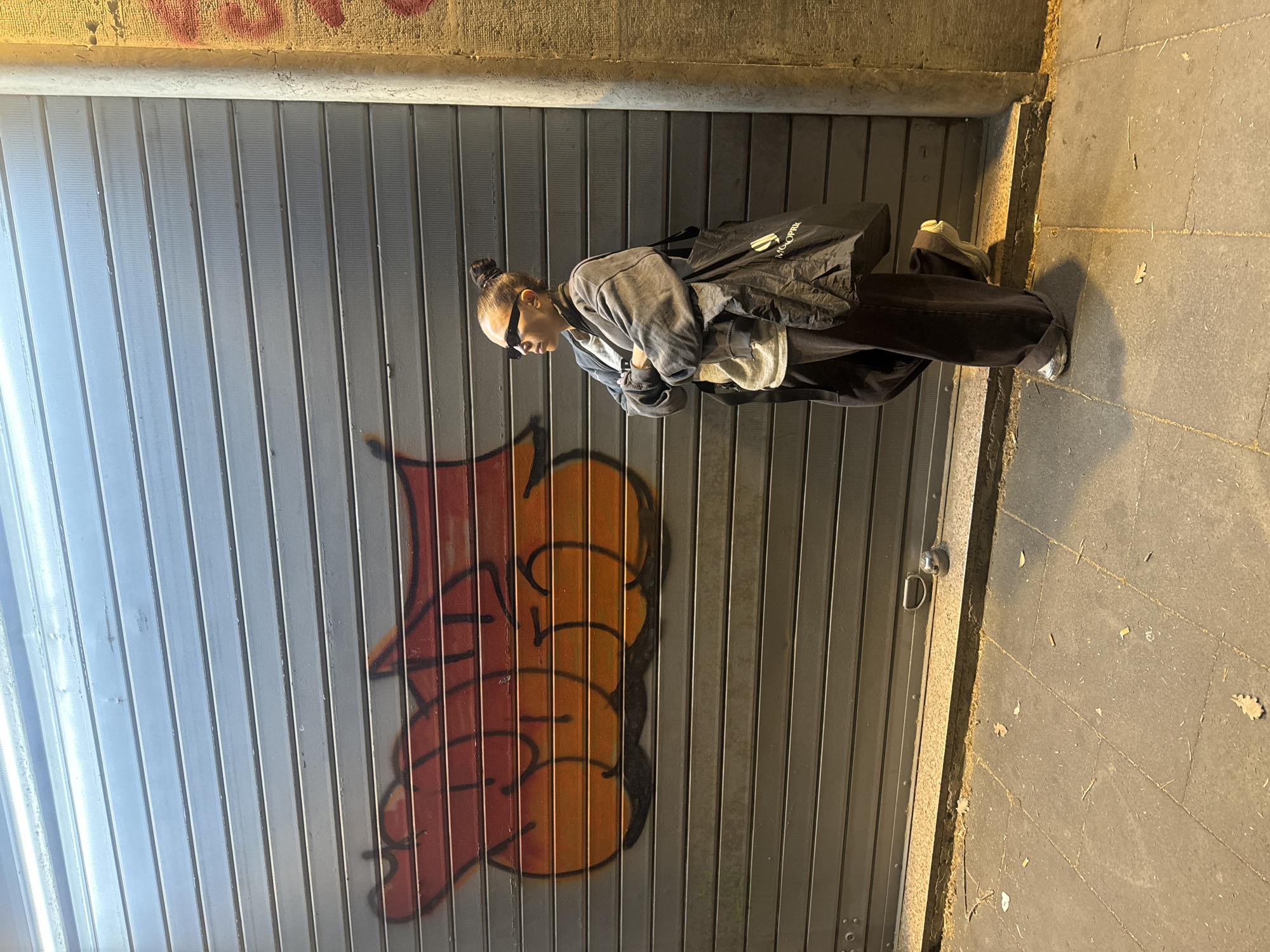 Woman poses by graffitied storefront in Rome