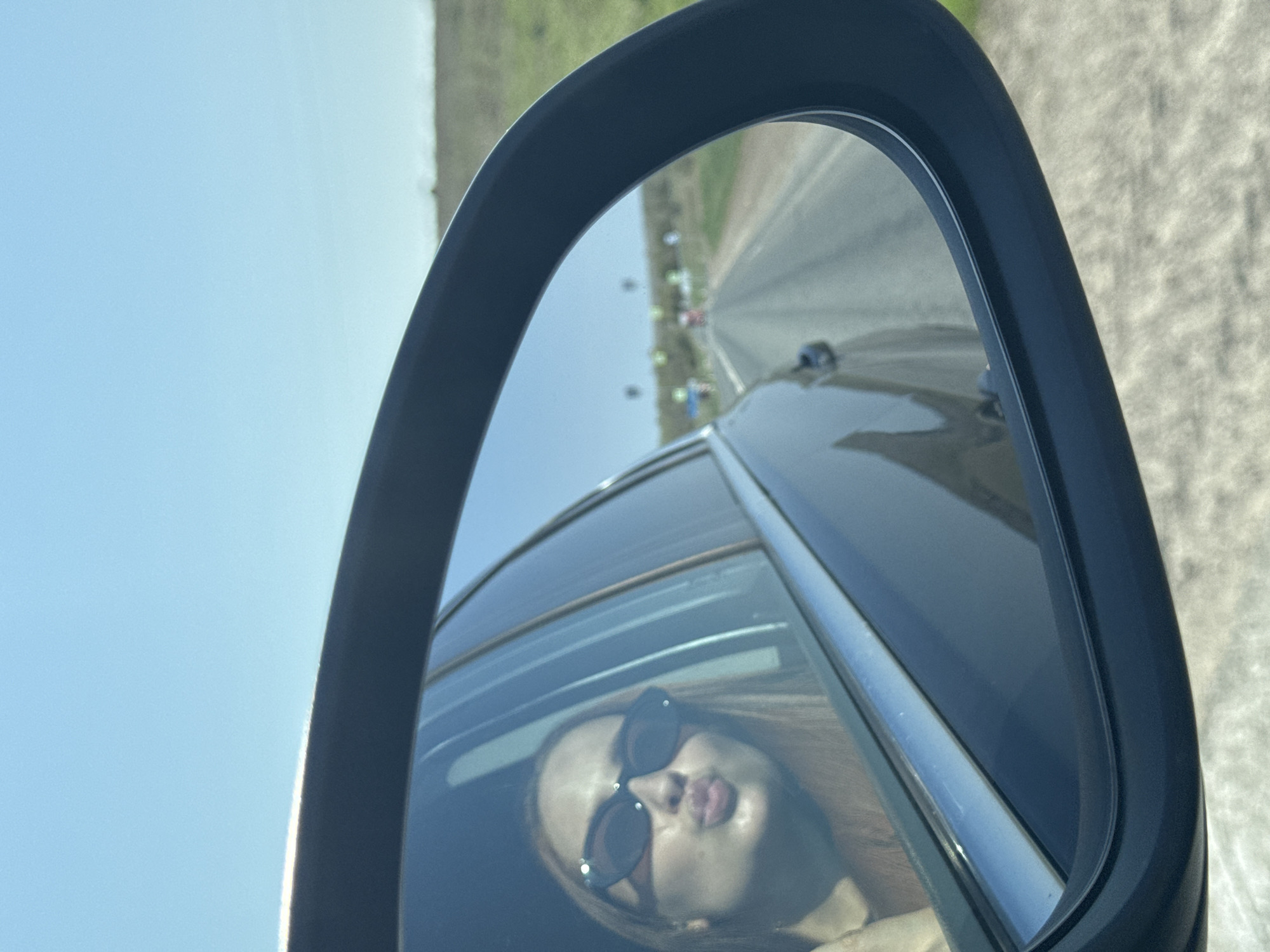 Woman in sunglasses spotted in car mirror, Polozovo Russia