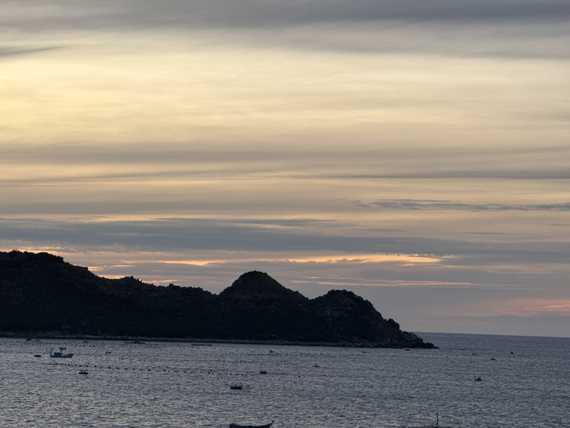 Dusk from a beach balcony, boats and islands on the horizon