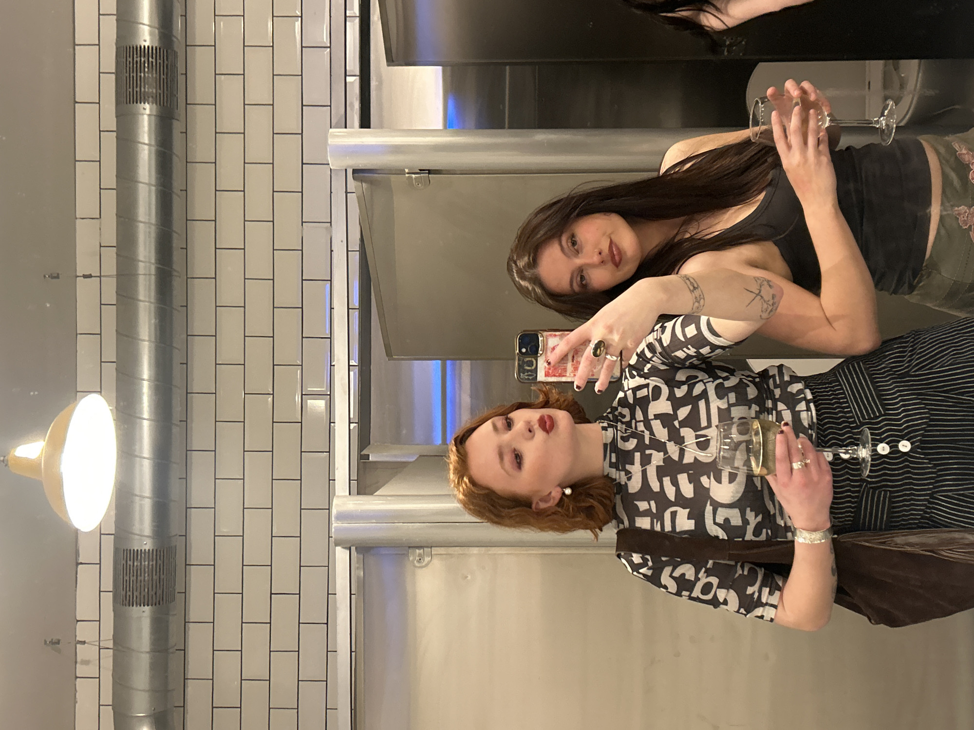 Two women take mirror selfie in Dundee restroom