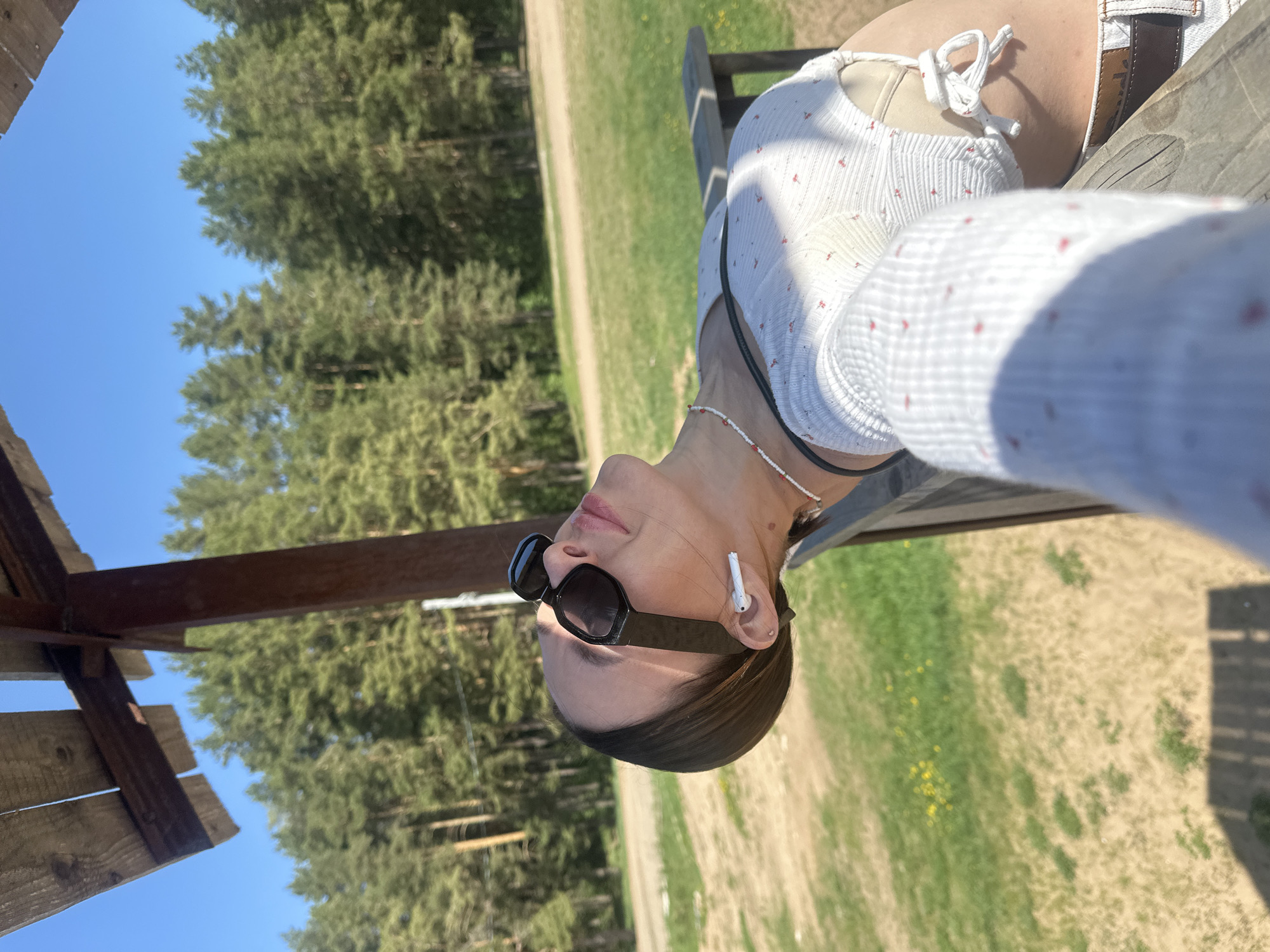 Woman rests at wooden structure in Votkinsk forest area