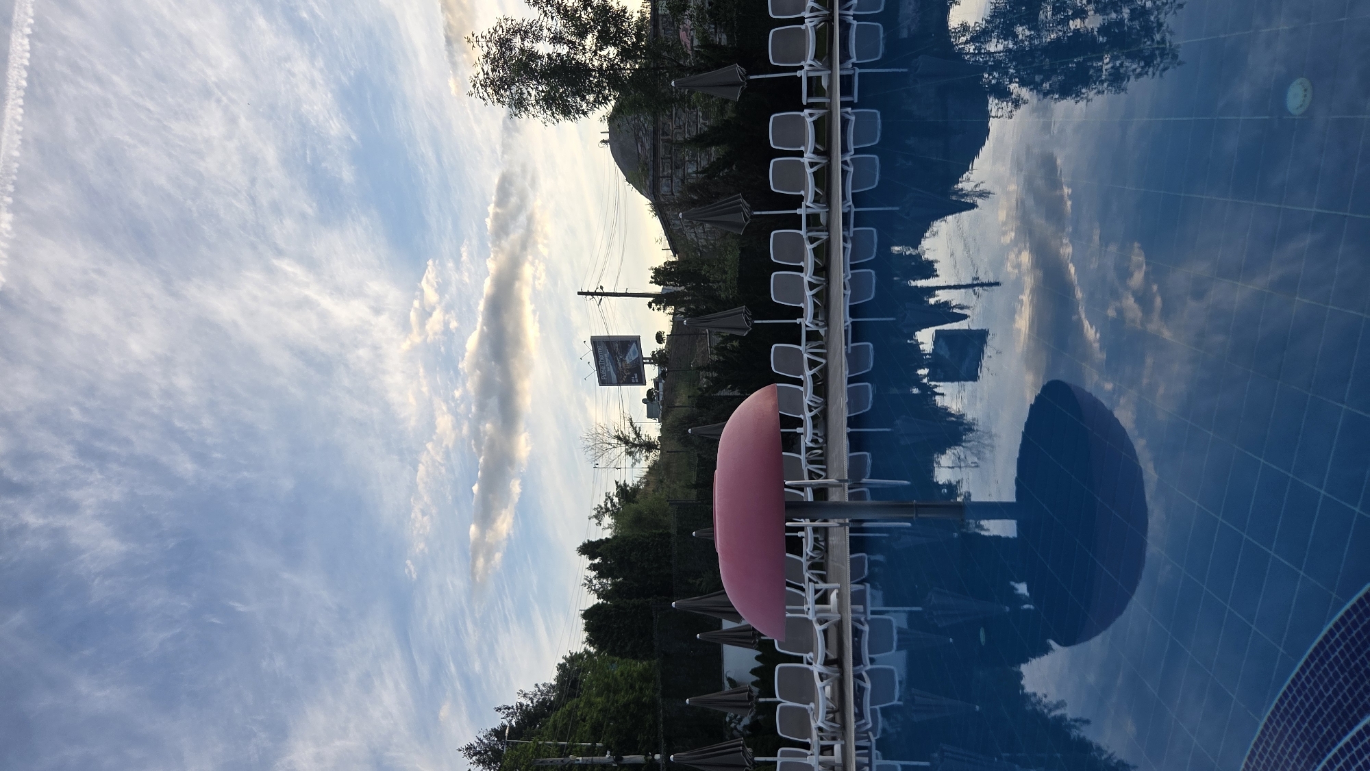 Aiper robotic pool cleaner beside a backyard pool at dusk