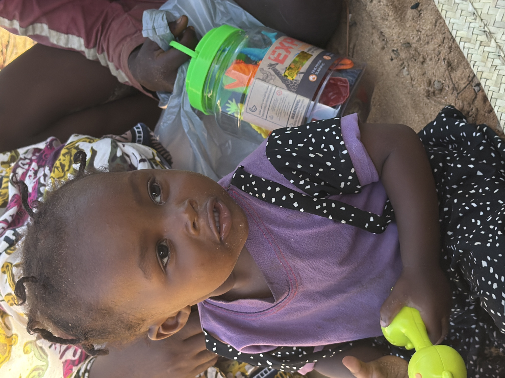 Child with green object photographed in Pemba, Mozambique