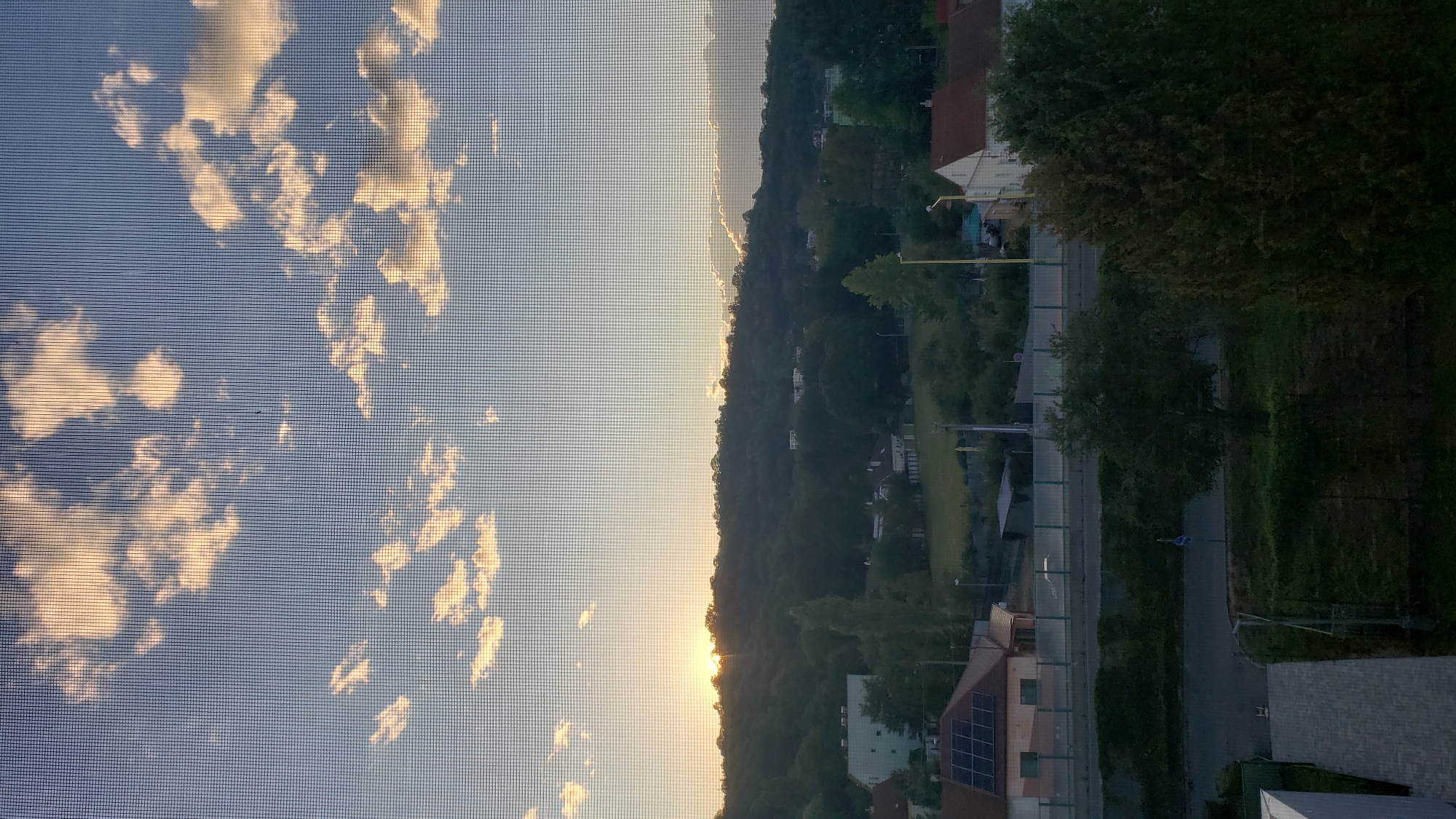 Sunset over Prešov, Slovakia, seen through a window screen
