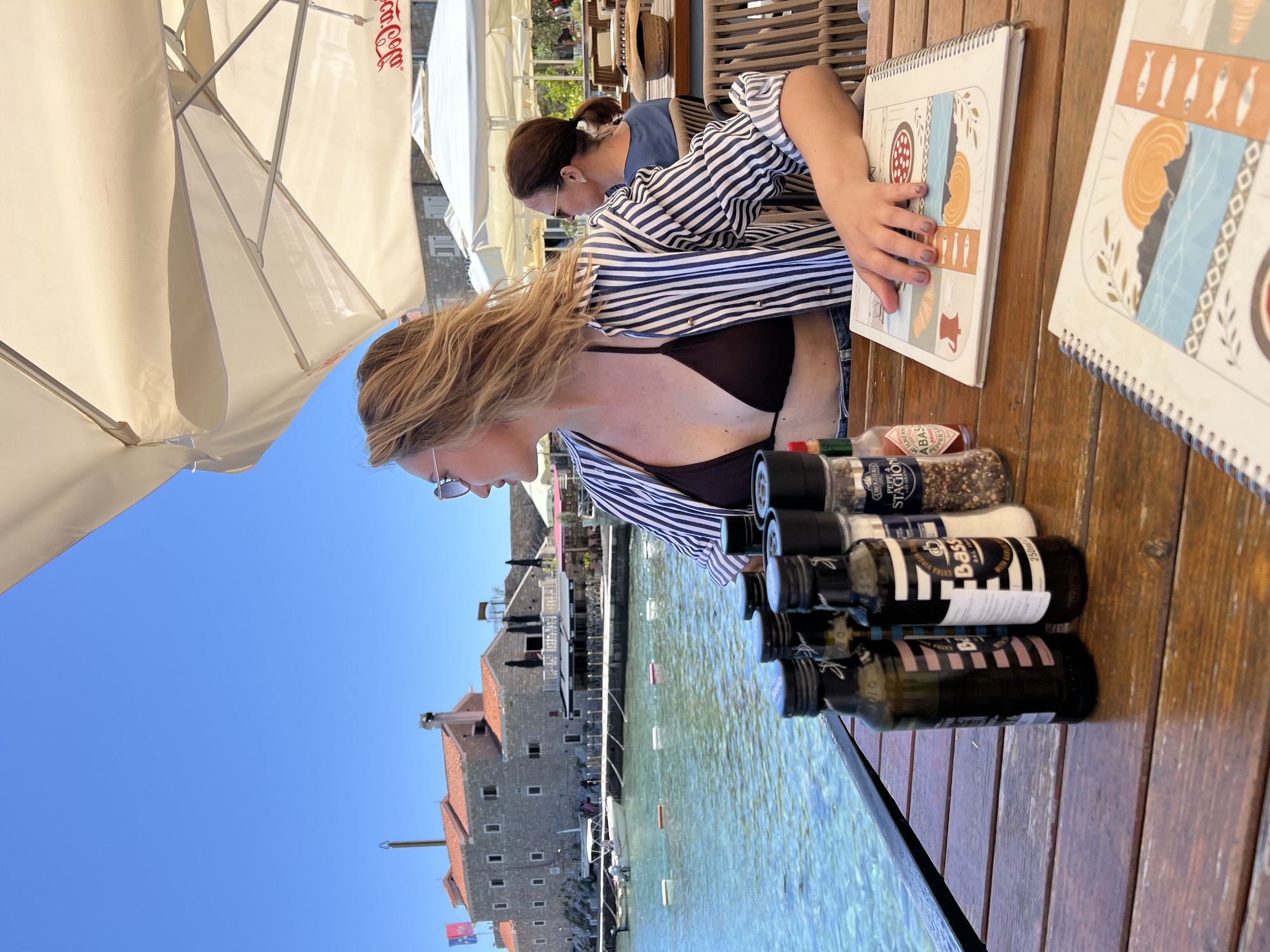 Tourist enjoys sunny afternoon dining and beachwalking in Petrovac
