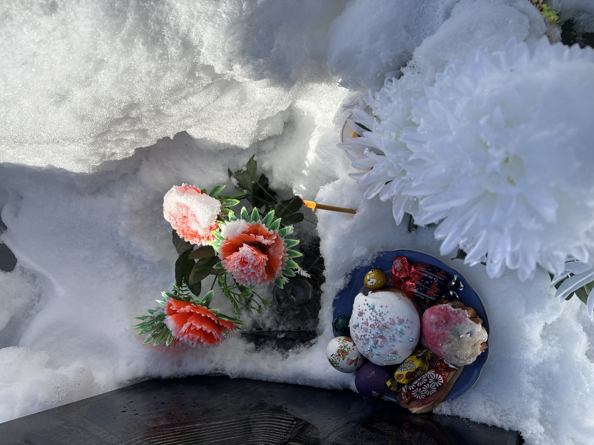 Memorial offerings left on snowy grave site in Russia
