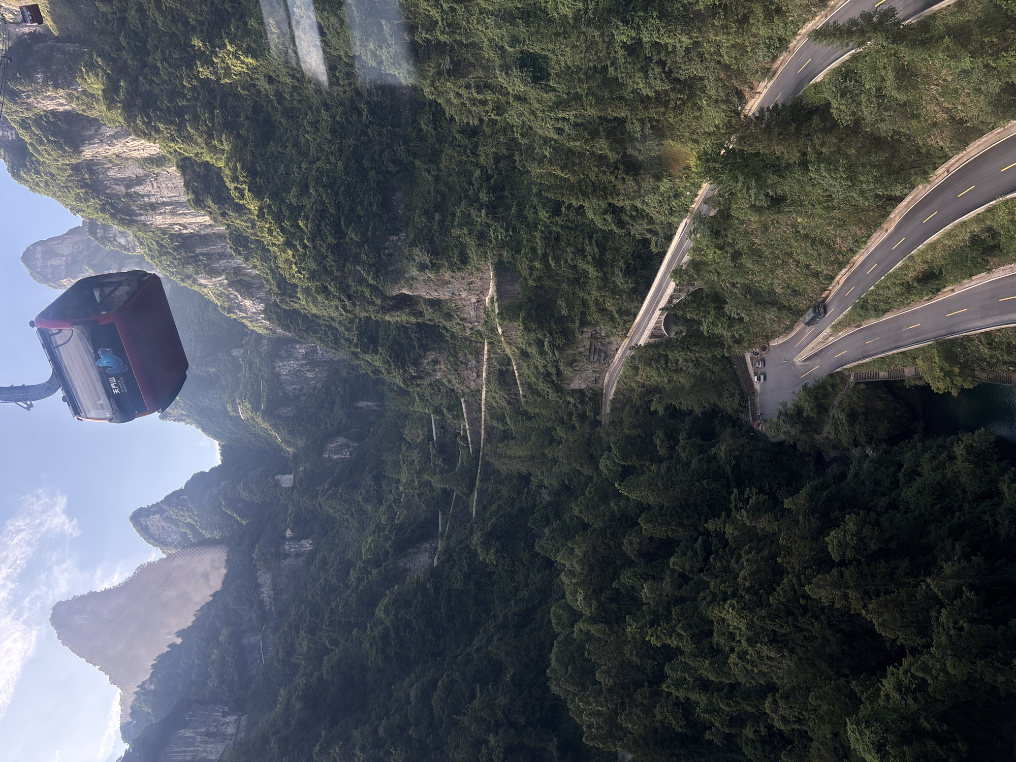 Cable cars crossing steep green peaks at Tianmen Mountain