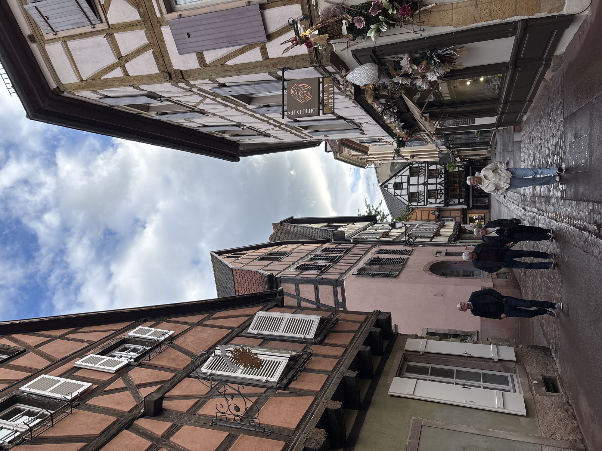 Tourist documents historic Colmar architecture during walking tour