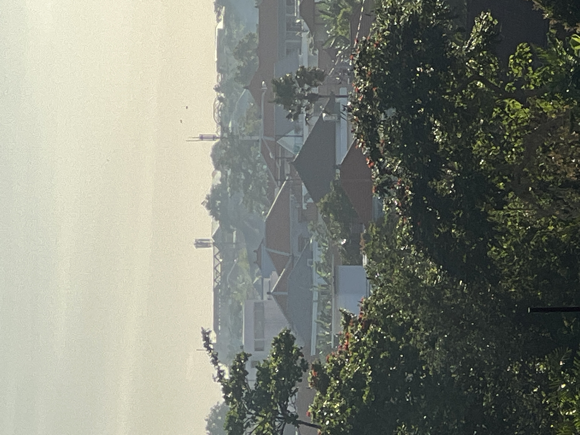 Resident washes scooter in tropical North Kuta morning