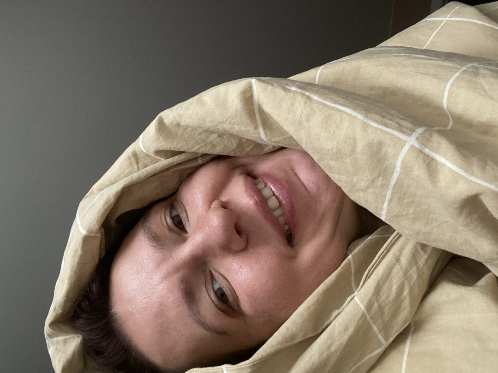 Woman photographed smiling under blanket in Chaikovsky, Russia