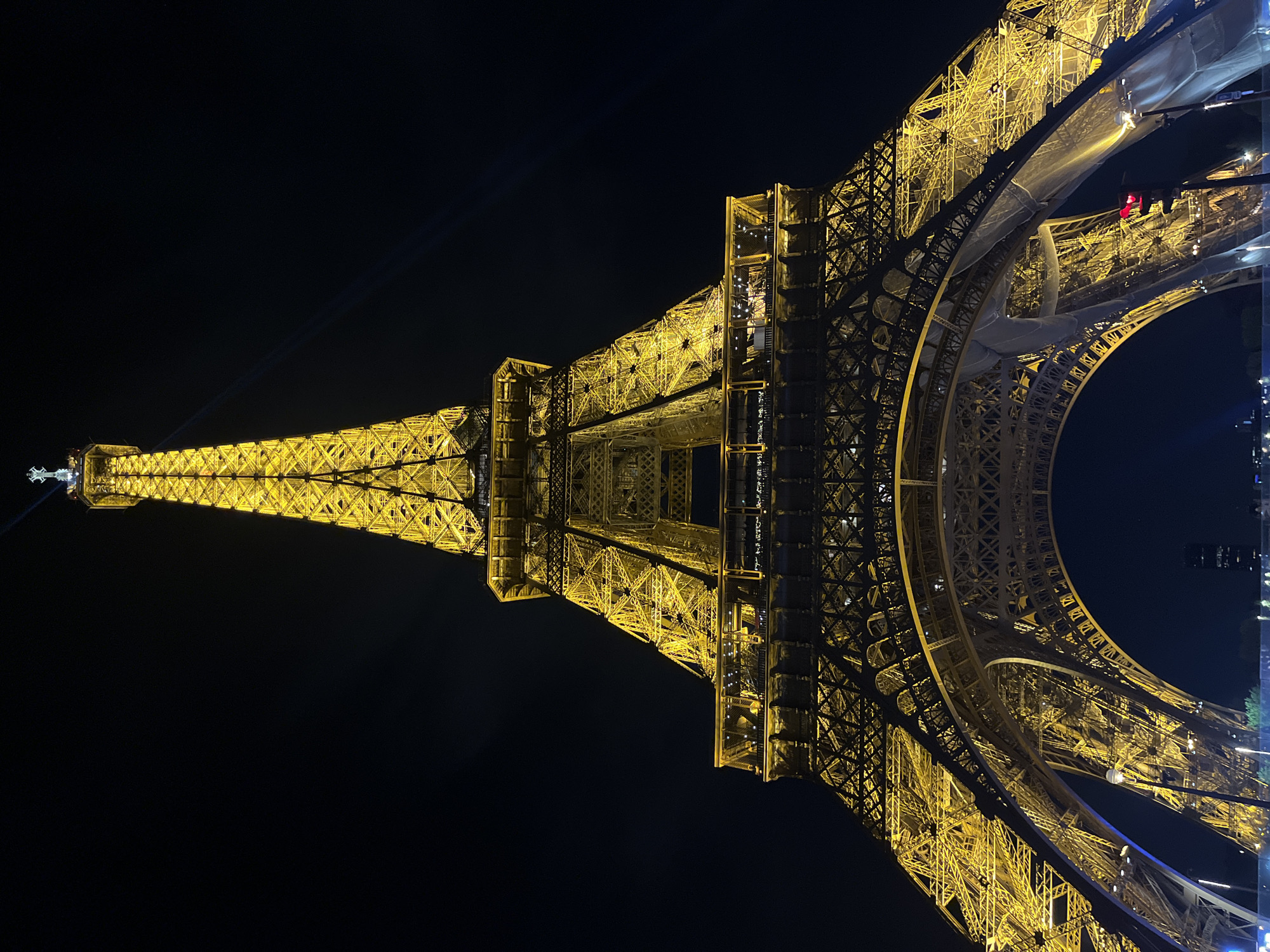 Eiffel Tower displays golden nighttime illumination in Paris
