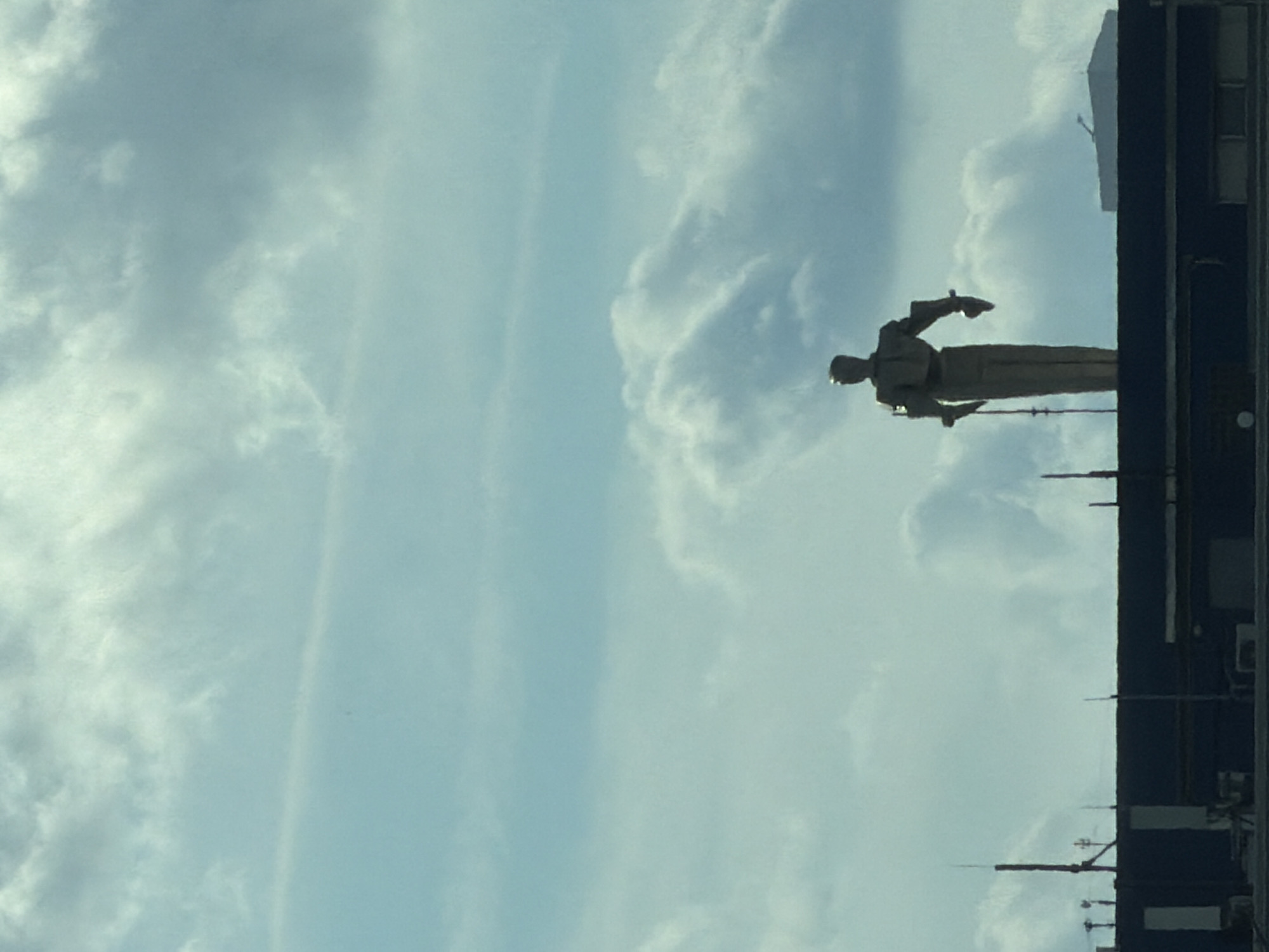 Suited statue silhouetted atop a Moscow industrial building