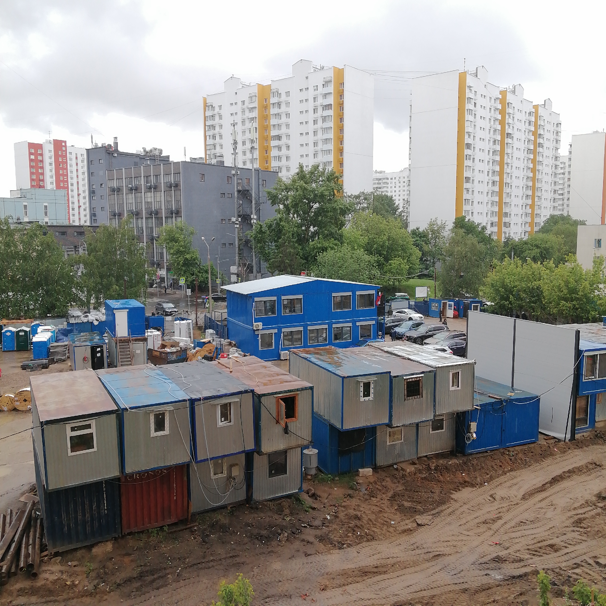 Urban construction site with stacked modular buildings observed