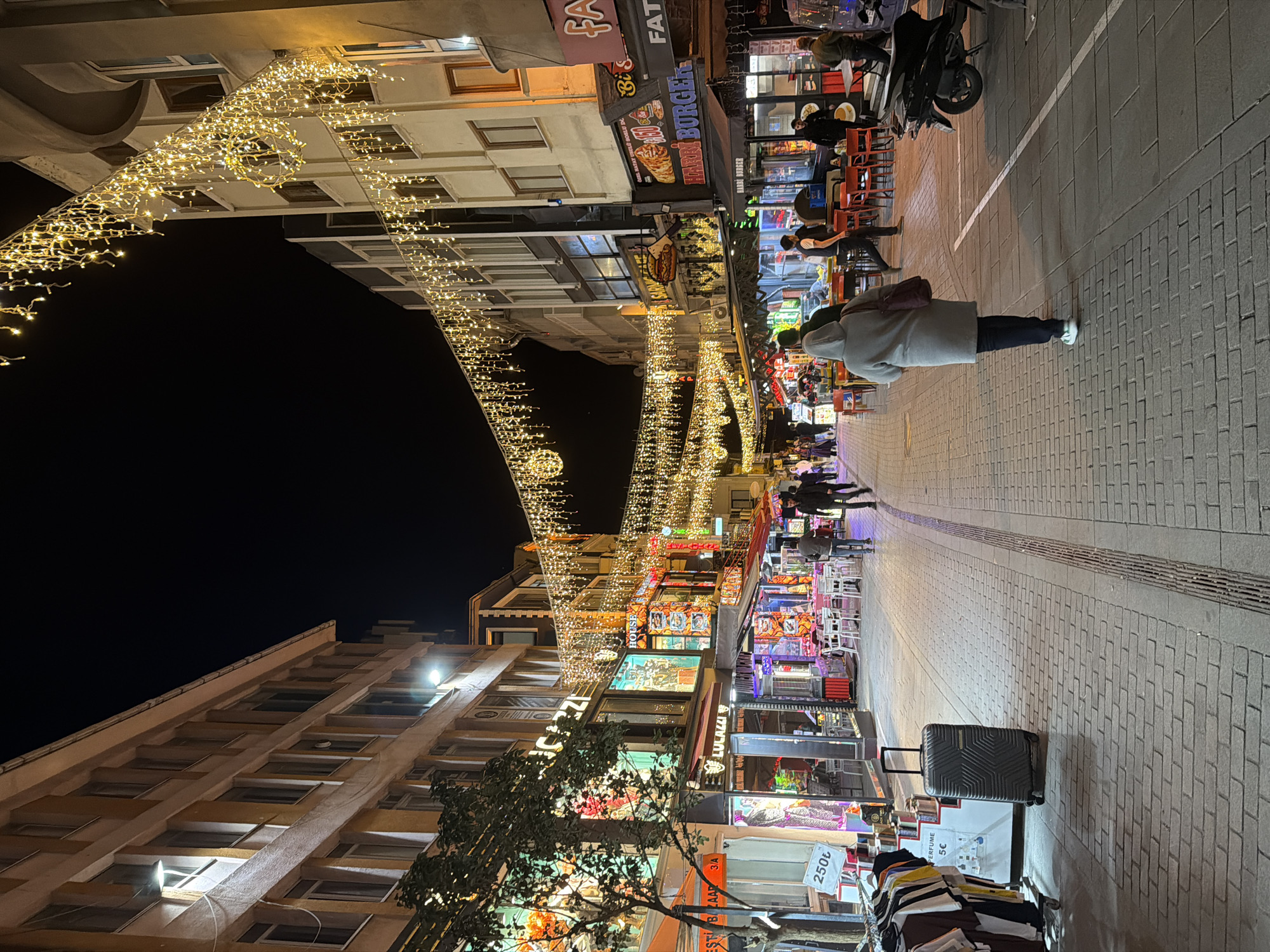 Couple captures nighttime selfie on illuminated Istanbul pedestrian street