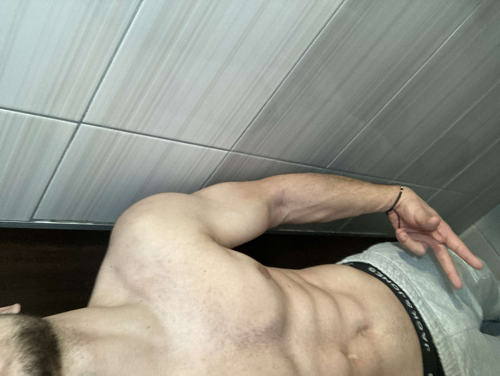 Man takes shirtless selfies and poses indoors in Bulgaria
