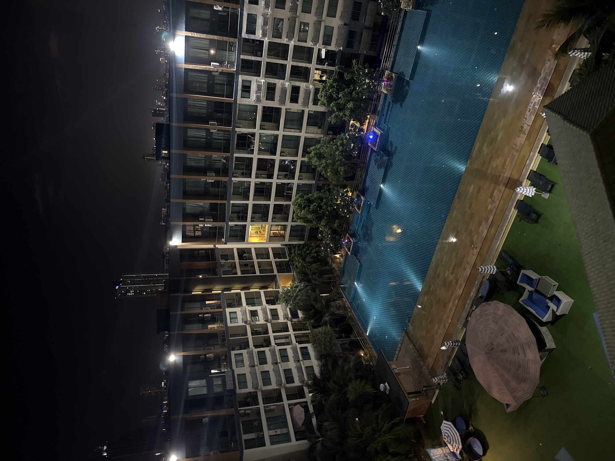 Nighttime aerial view captures lit resort pool in Pattaya