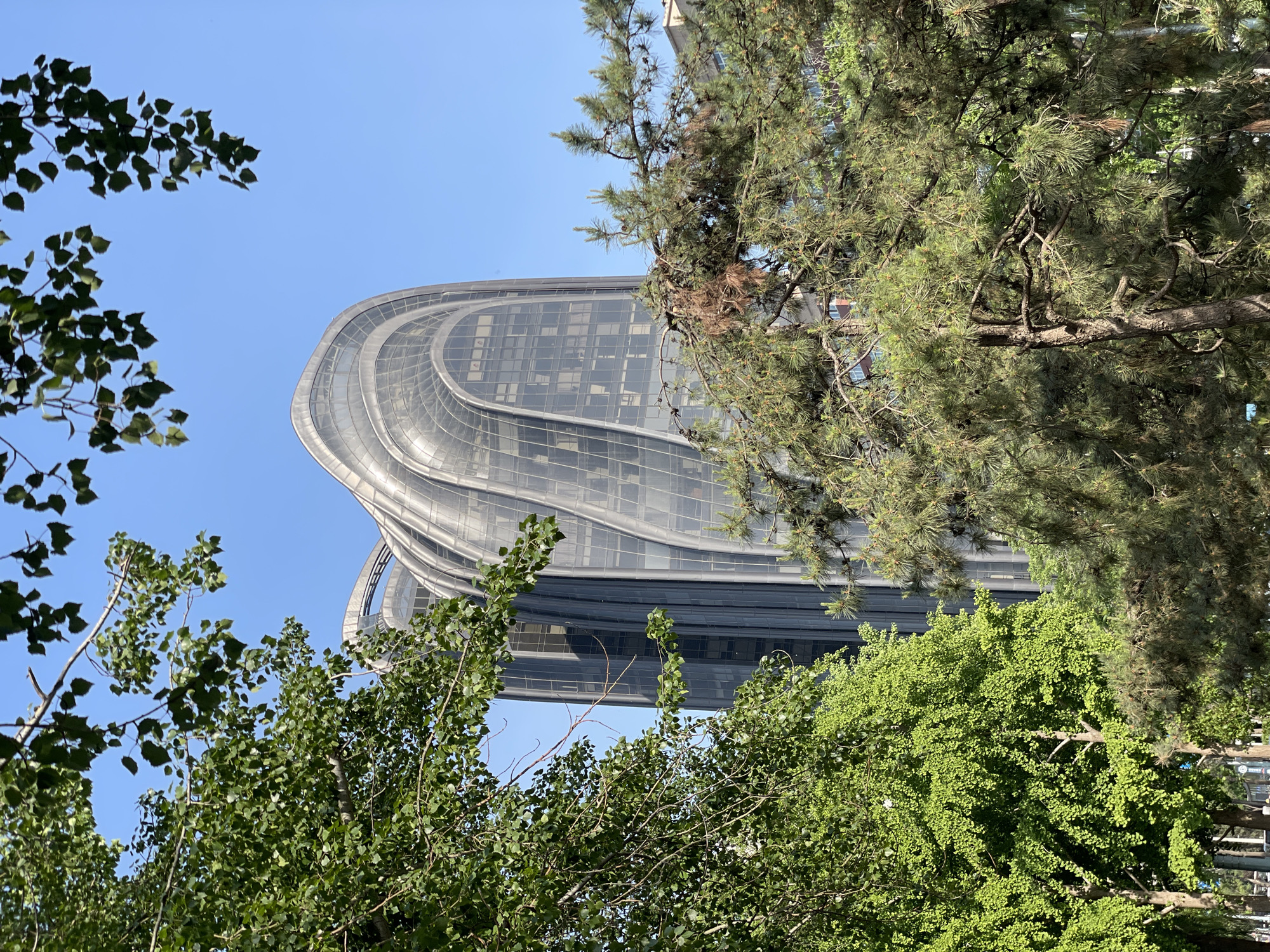 Modern curved-glass building photographed in Beijing's Chaoyang District