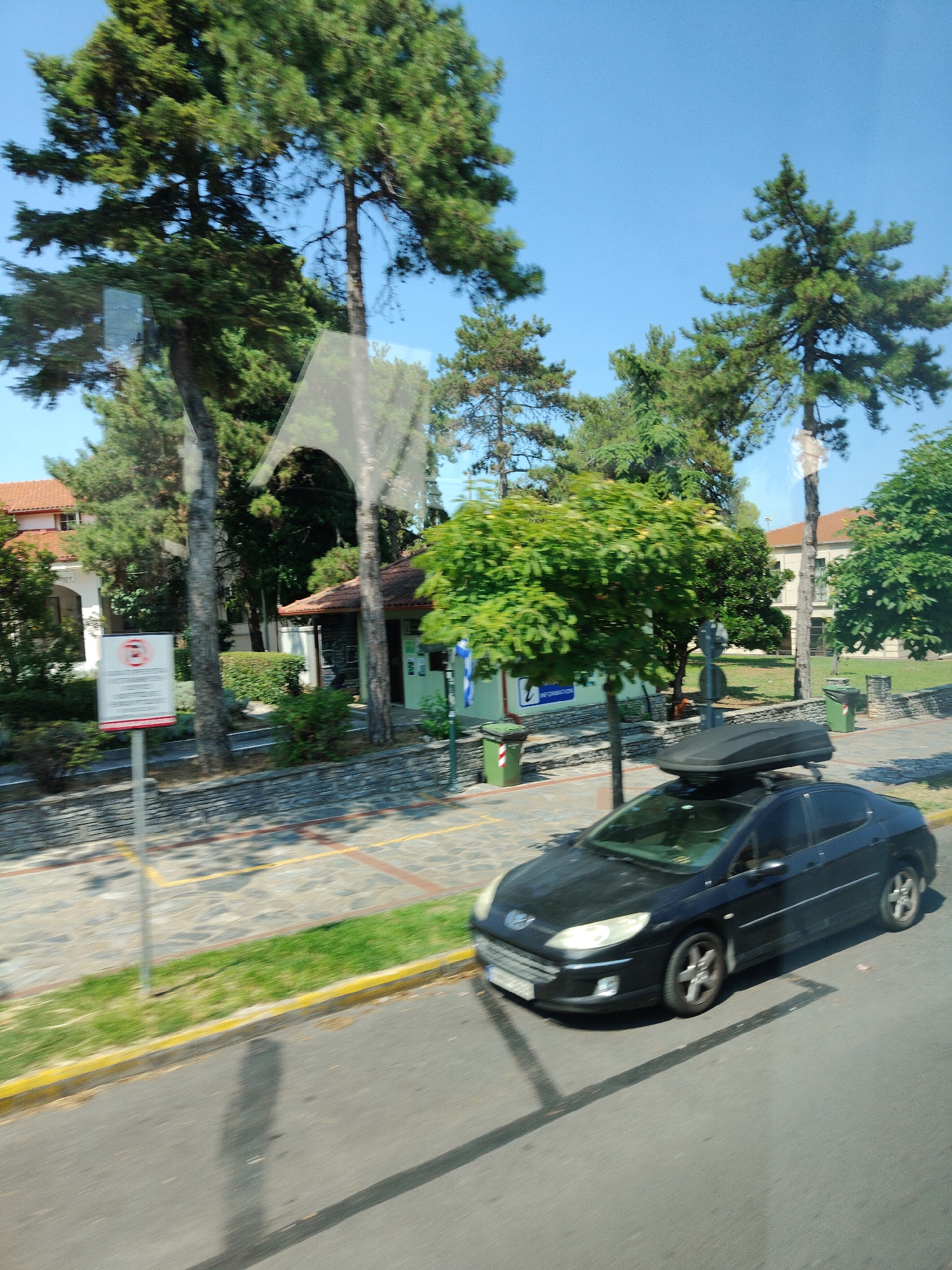 Parked car and mountain backdrop in sunny Litochoro