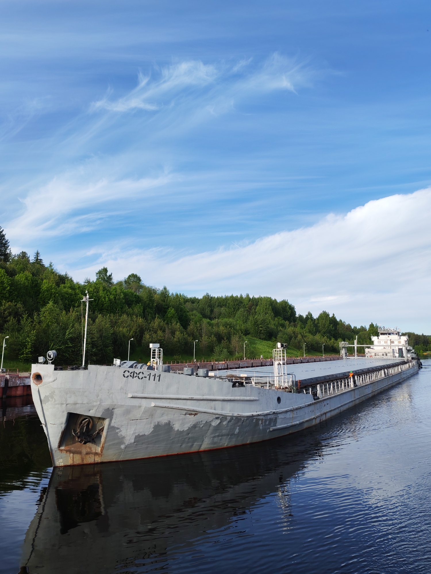 Commercial vessels navigate waterway in Markovo, Russia