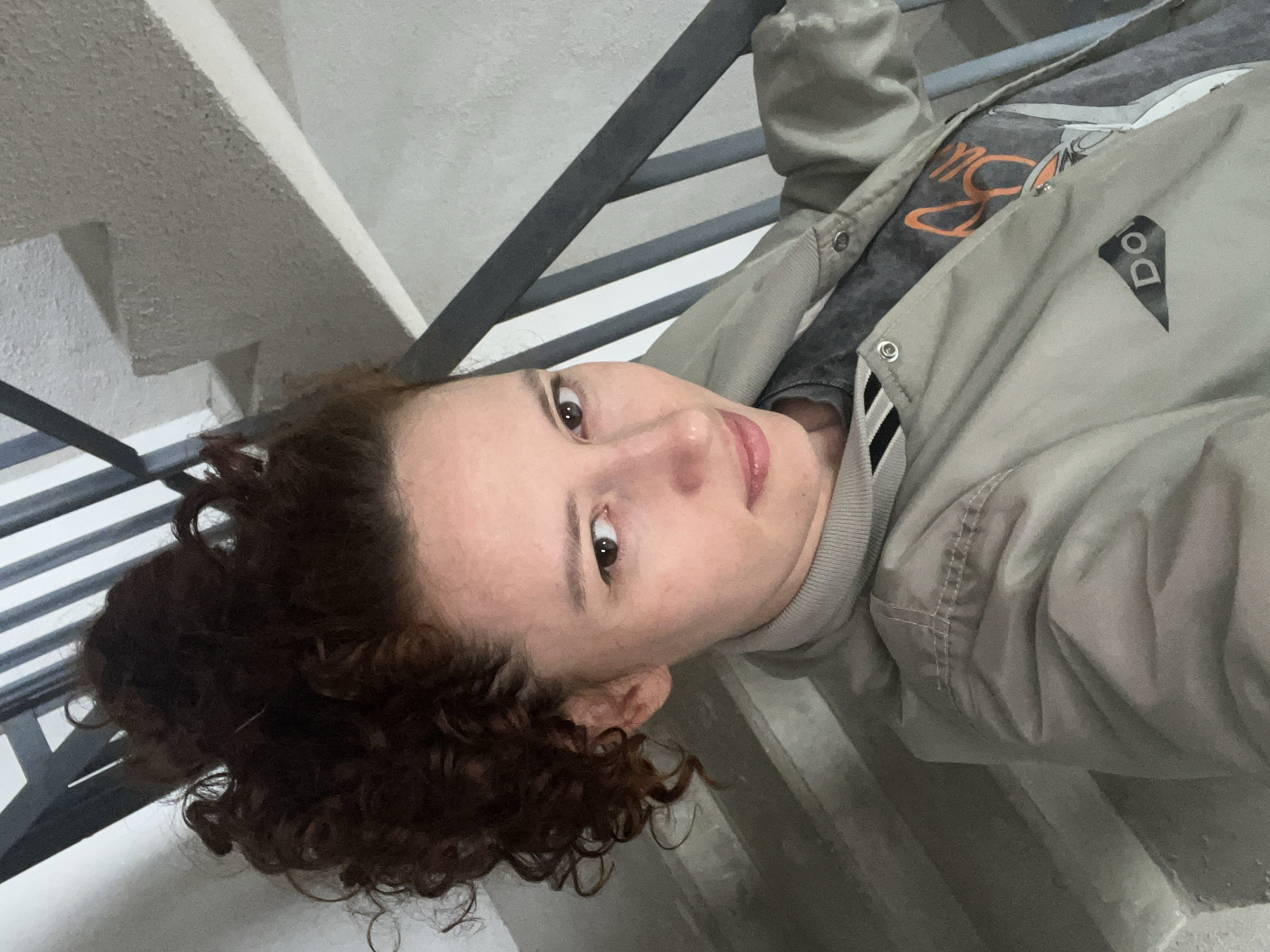 Person in bomber jacket sits on steps in Saint Petersburg