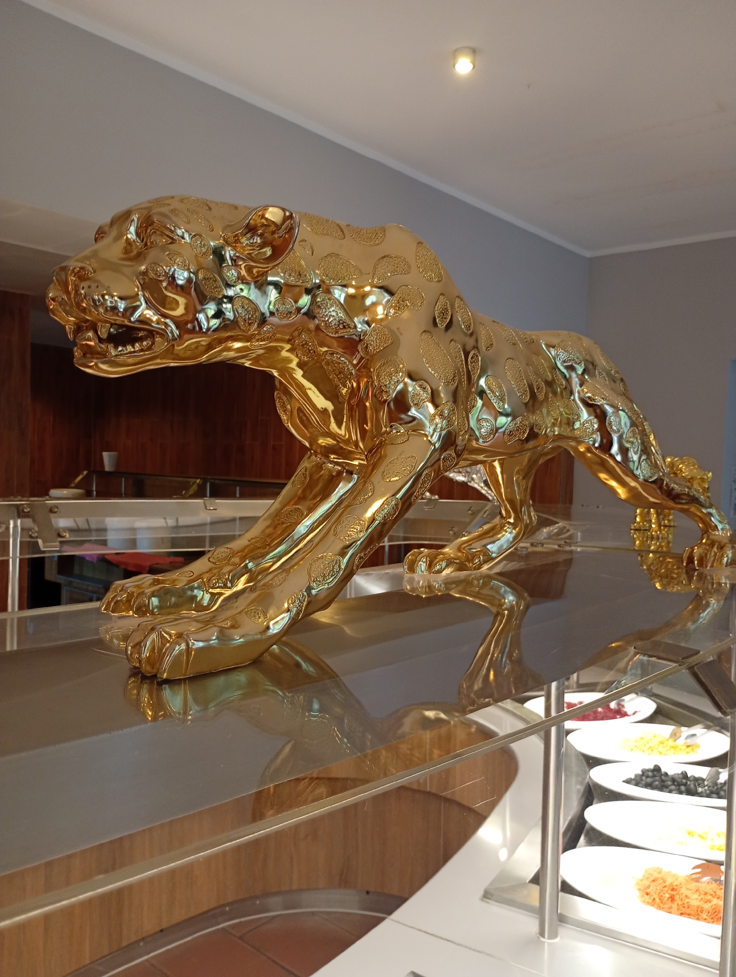 Elaborate restaurant buffet spread with seafood, sushi, and gold leopard décor