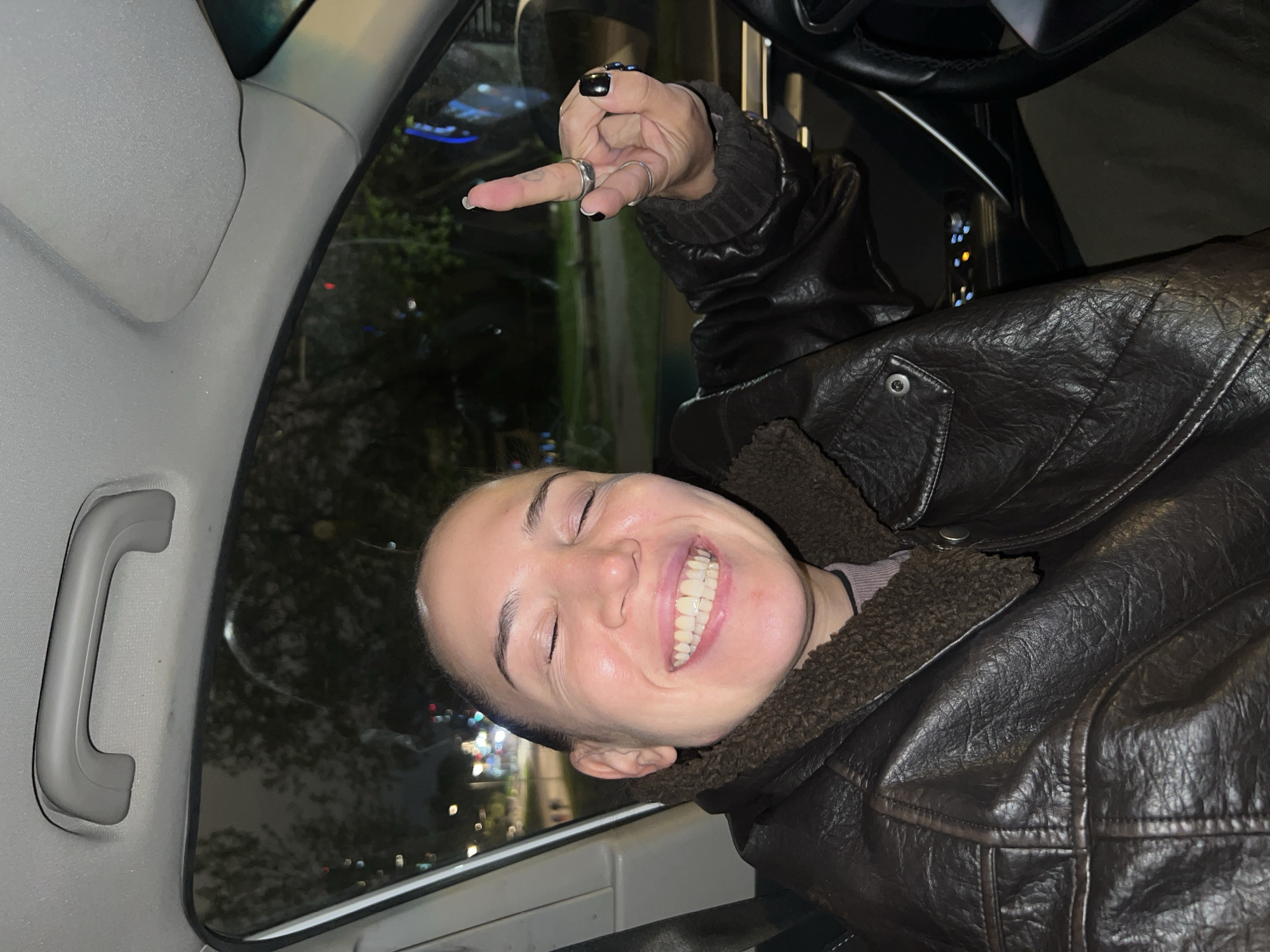 Person in leather jacket gestures from car in Moscow