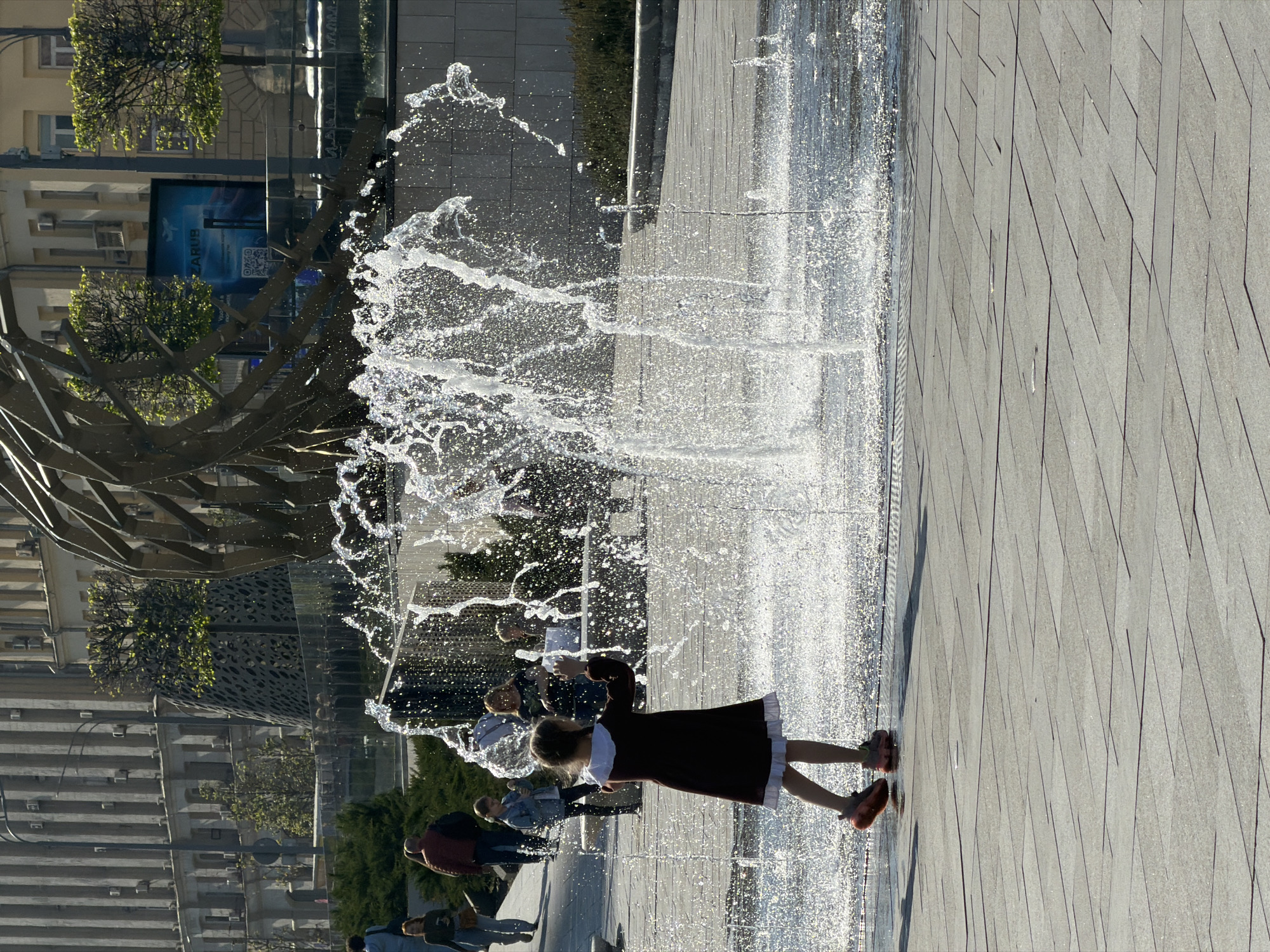 Girl in red dress interacts with water in Moscow