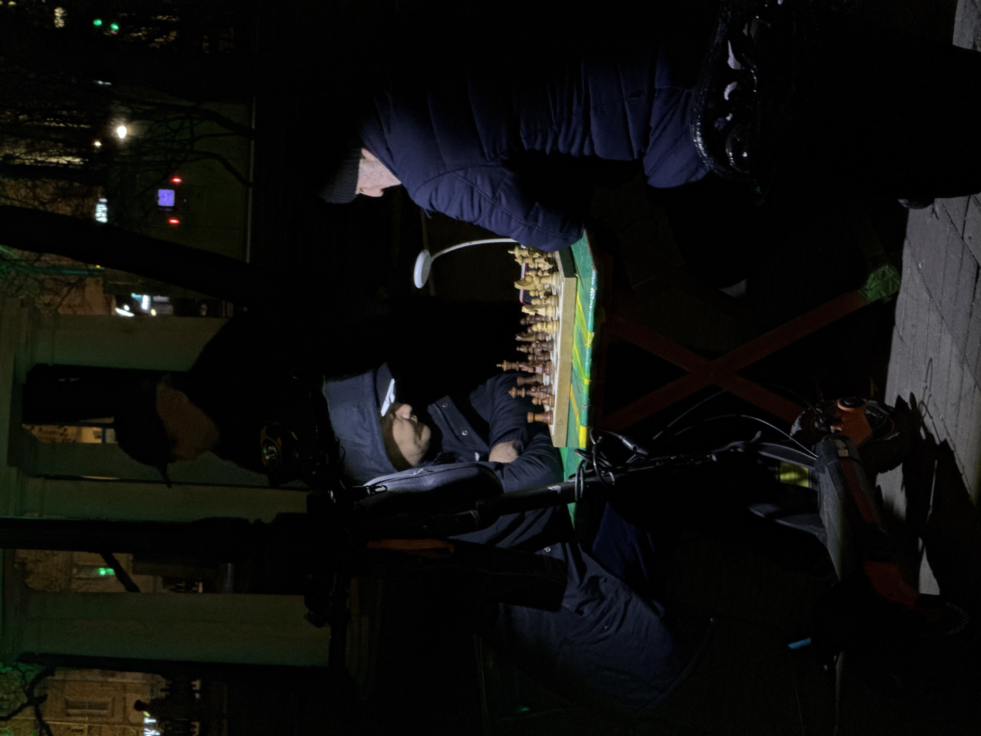 Nighttime chess match observed in Moscow street setting