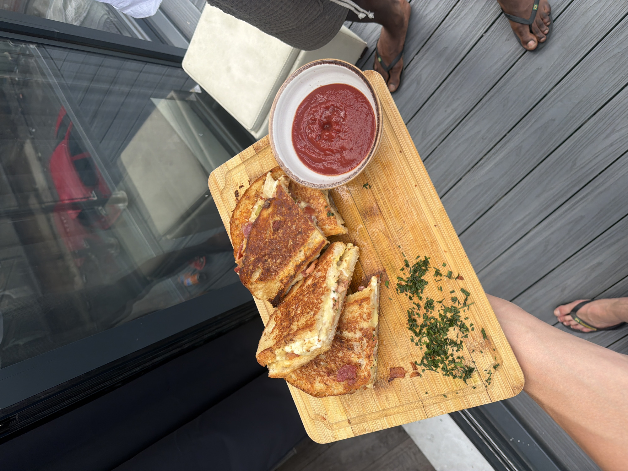 Grilled cheese sandwiches on a wooden board with ketchup