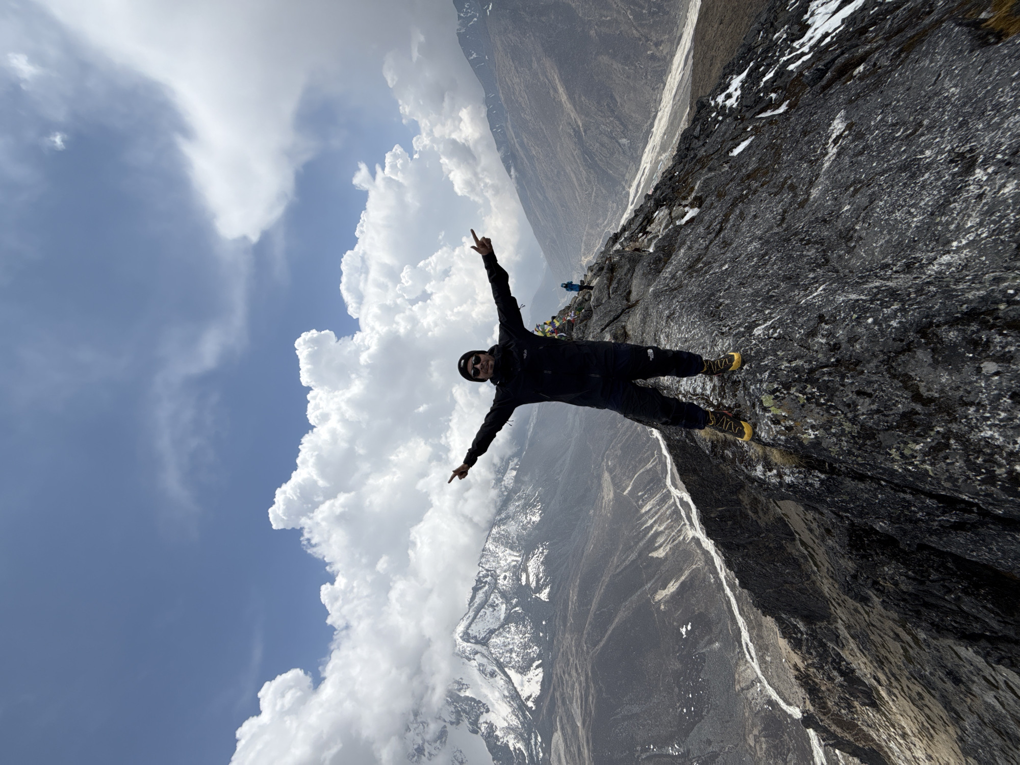 Hiker poses at prayer flag viewpoint in Nepal mountains