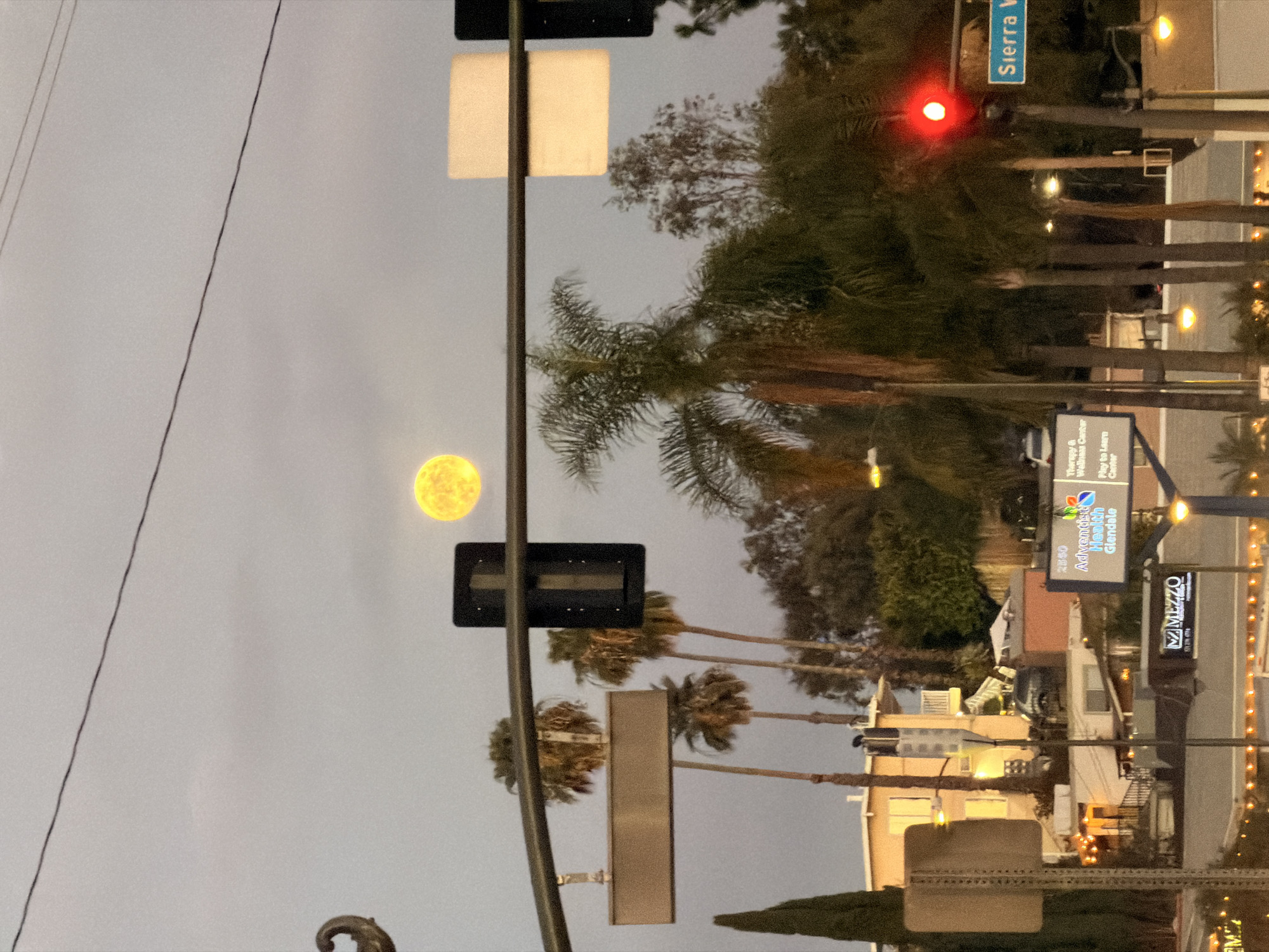 Big moon rises over LA streets at dusk