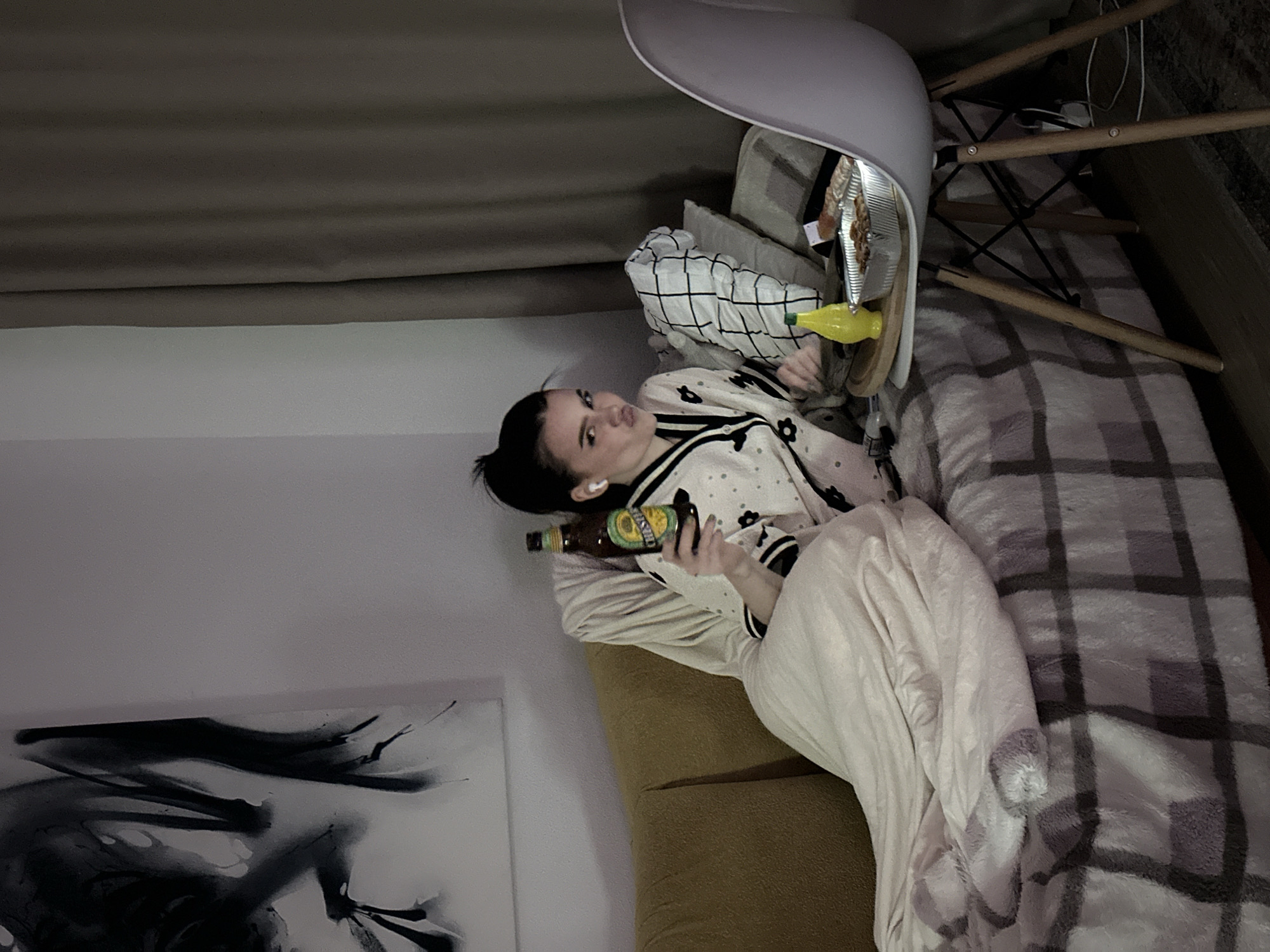 Woman relaxes on couch with bottle in Lyubertsy home