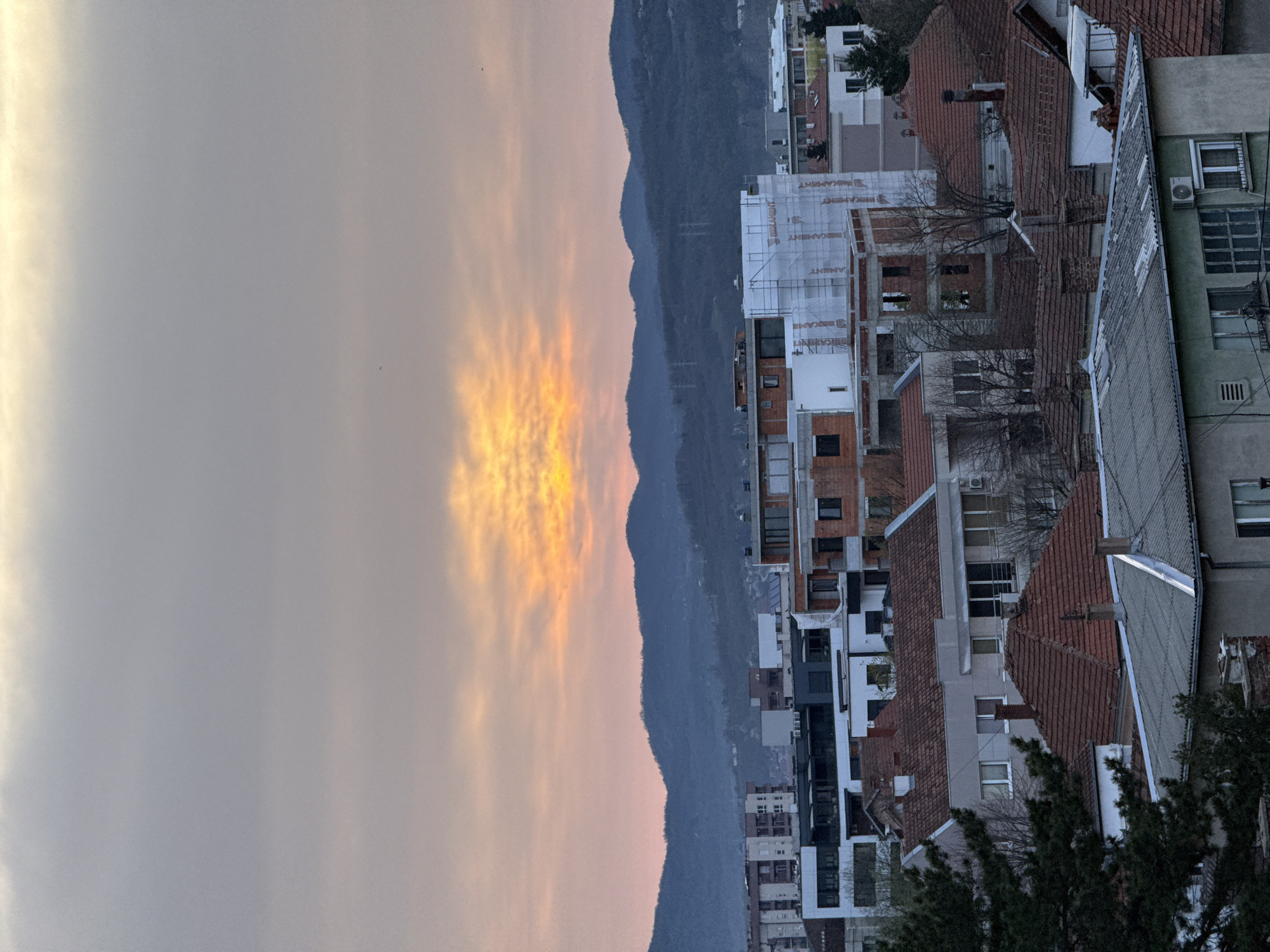 Sunset observed over Kragujevac cityscape with mountain backdrop