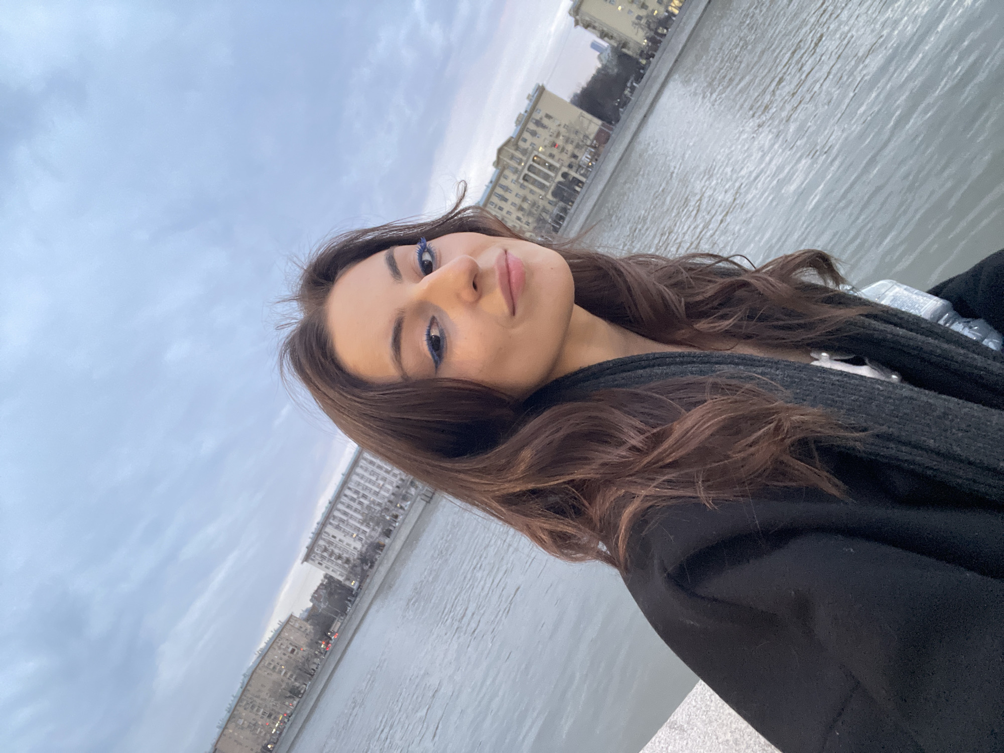 Woman takes selfies by Moscow river with blue makeup