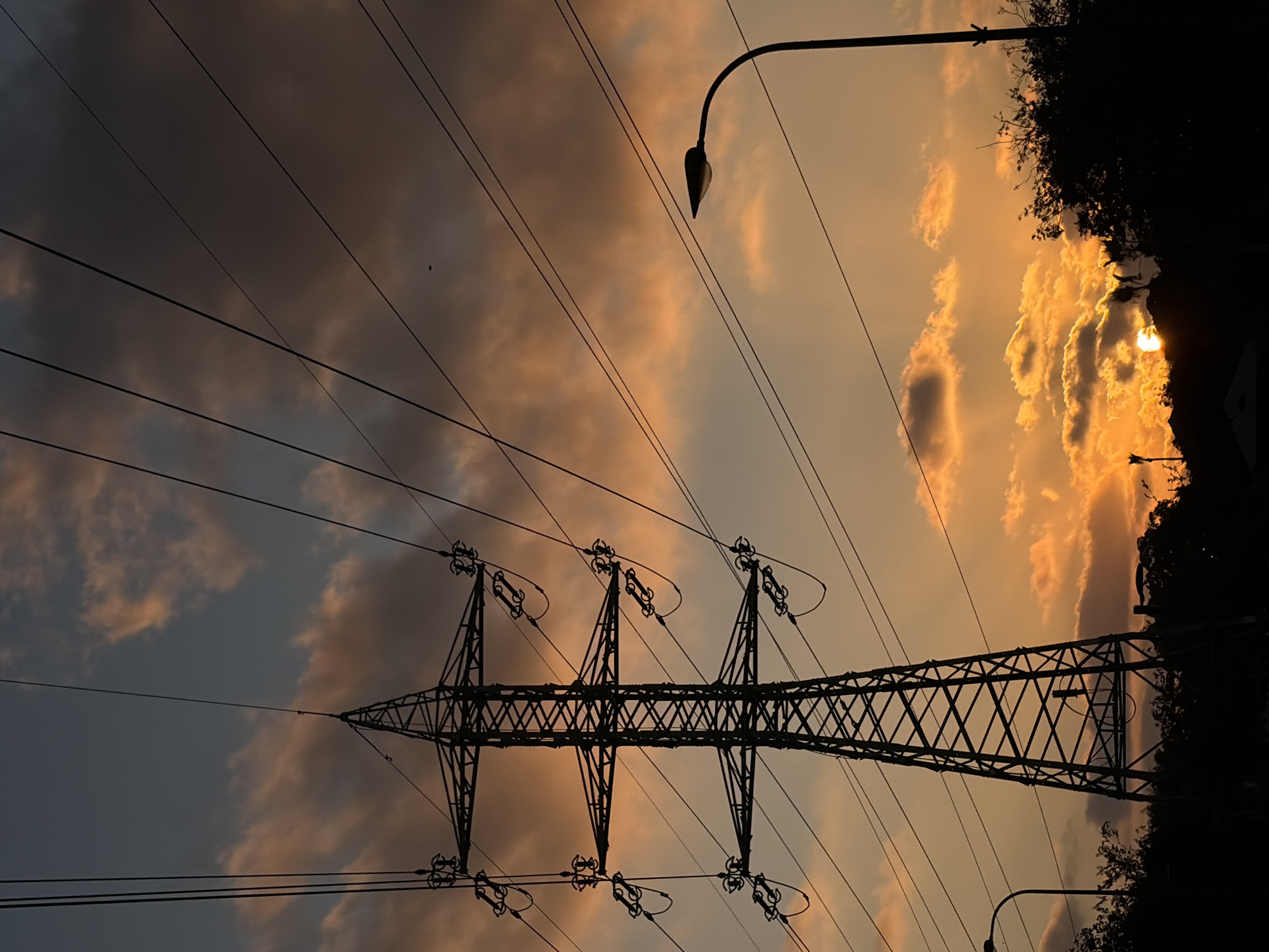 Tel Aviv sky at dusk: pylons, traffic lights, and a crescent moon