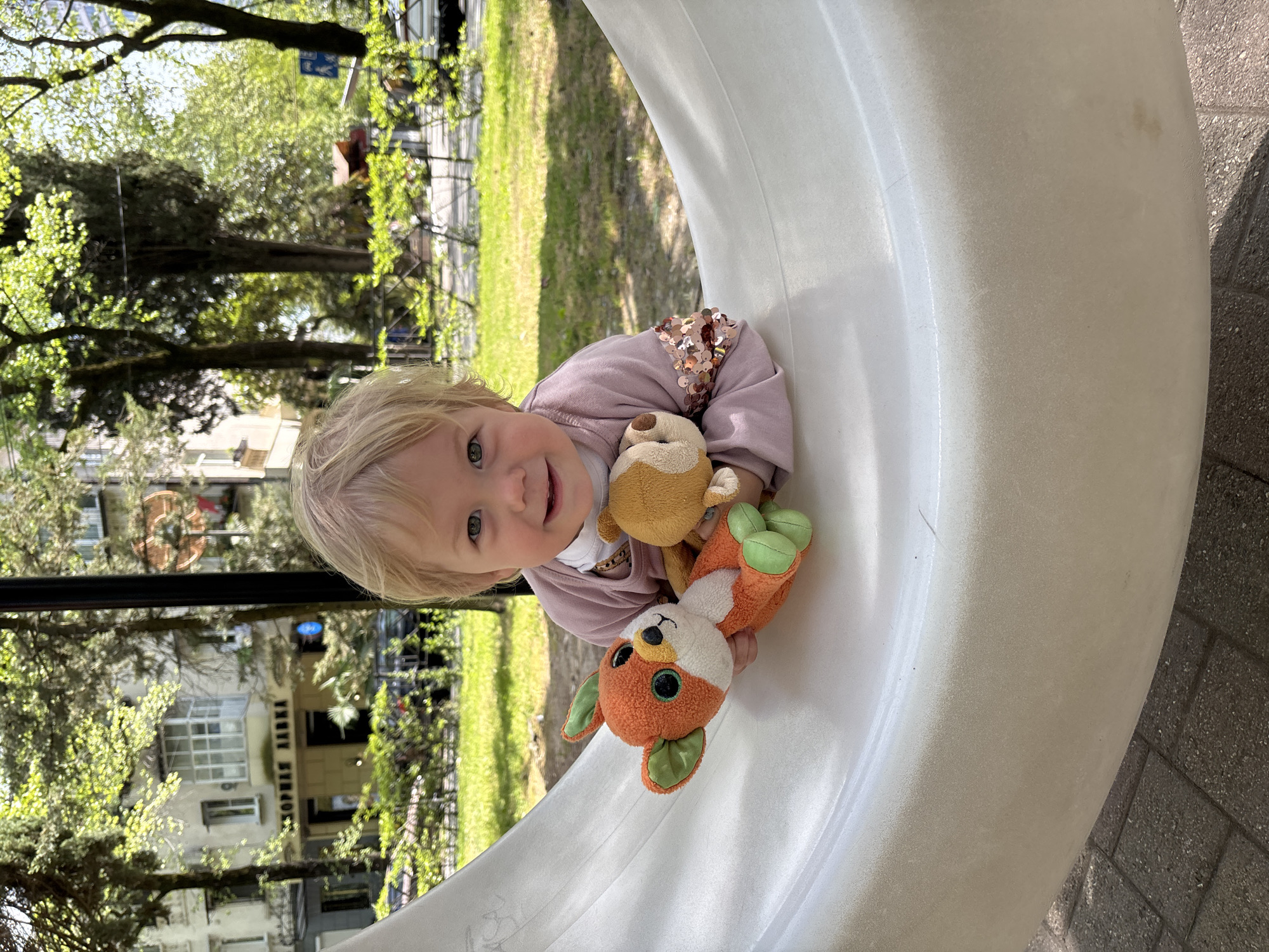Child plays with stuffed animals in white structure, Sochi