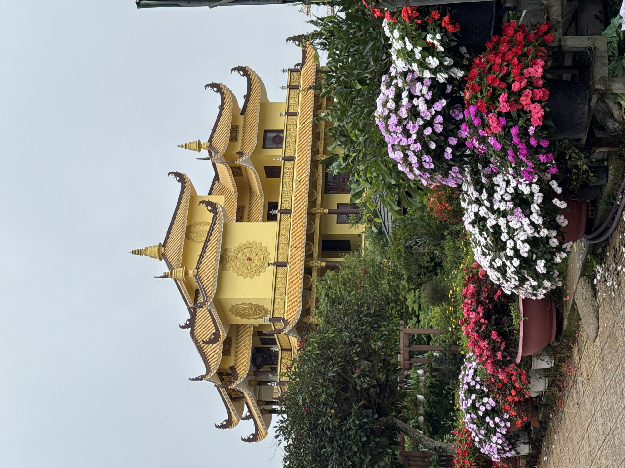 Ornate Buddhist temple and flower-lined walkway in Da Lat