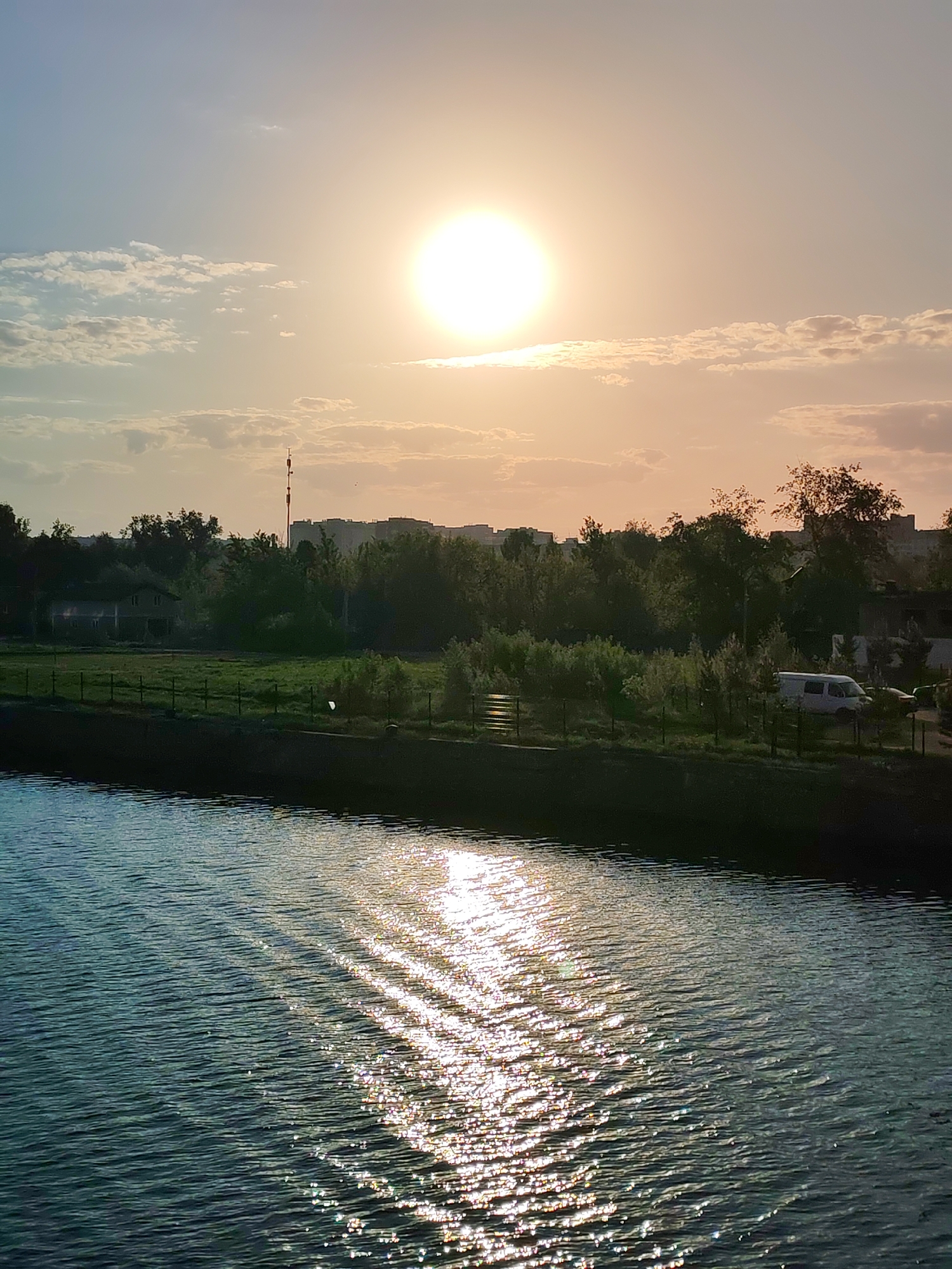 Sunset observed over Dmitrov waterfront with residential buildings