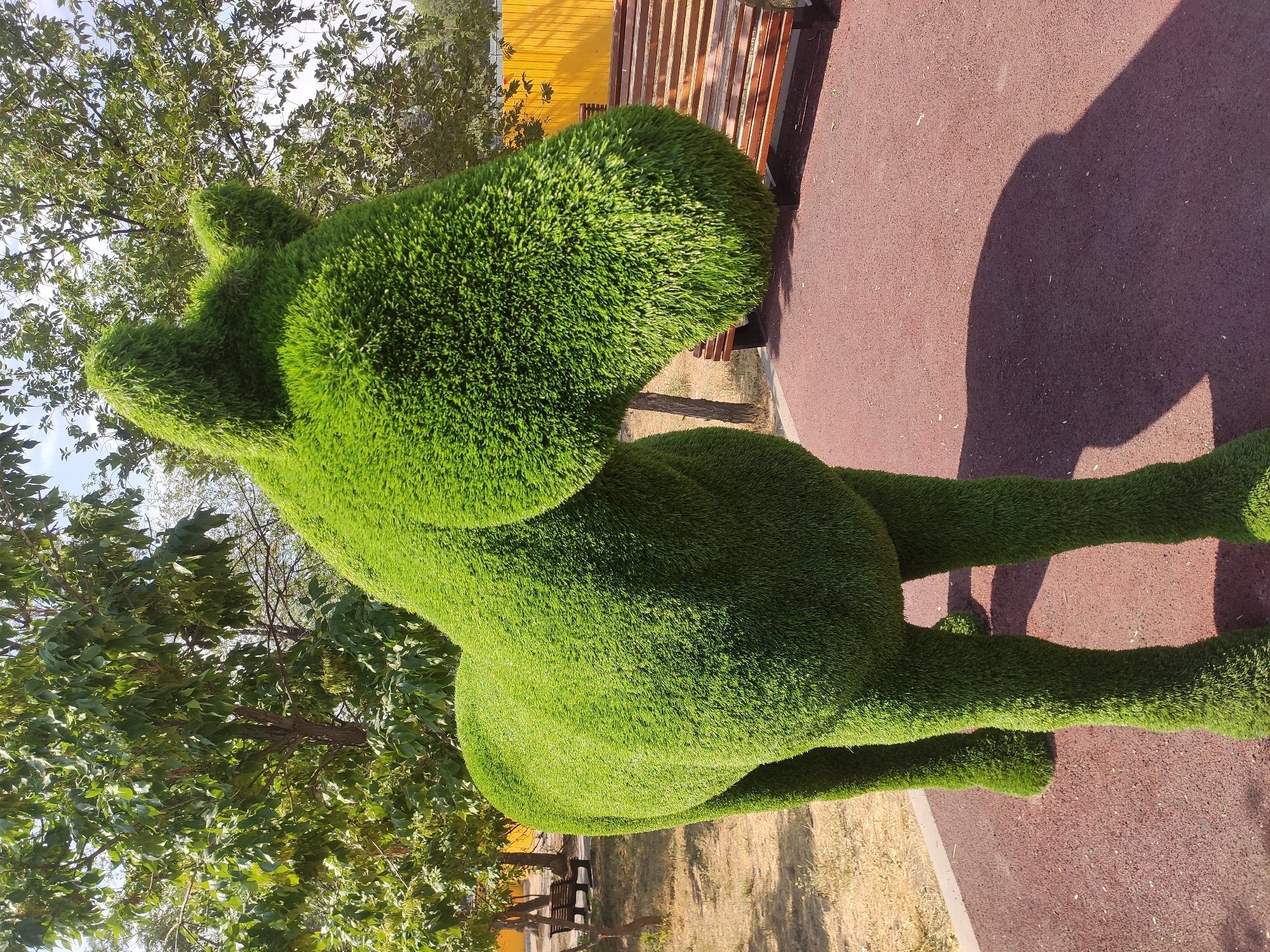 Yerevan park with topiary sculptures, monuments, and active construction