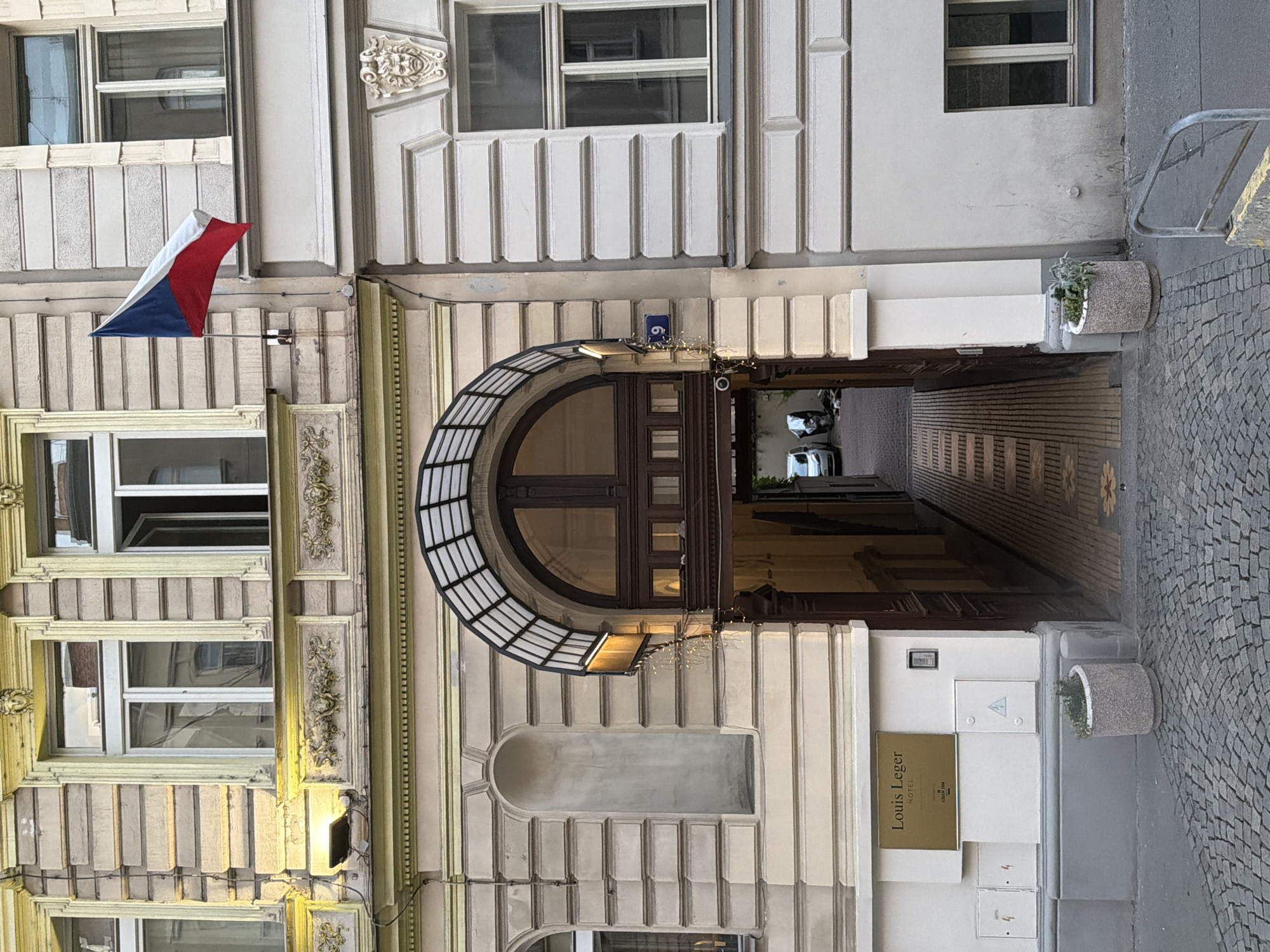 Louis Leger Hotel entrance, Prague historic building with Czech flag