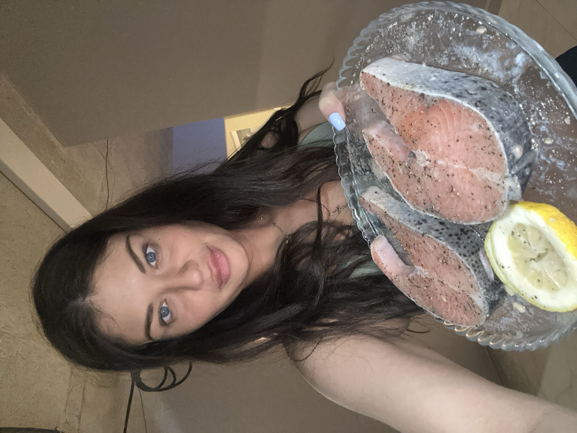Woman prepares seasoned salmon steaks in Khimki apartment