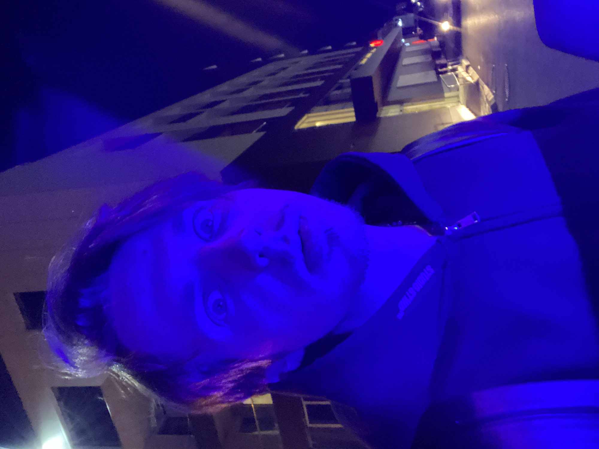Man photographed in blue lighting displays surprised expression in Bar