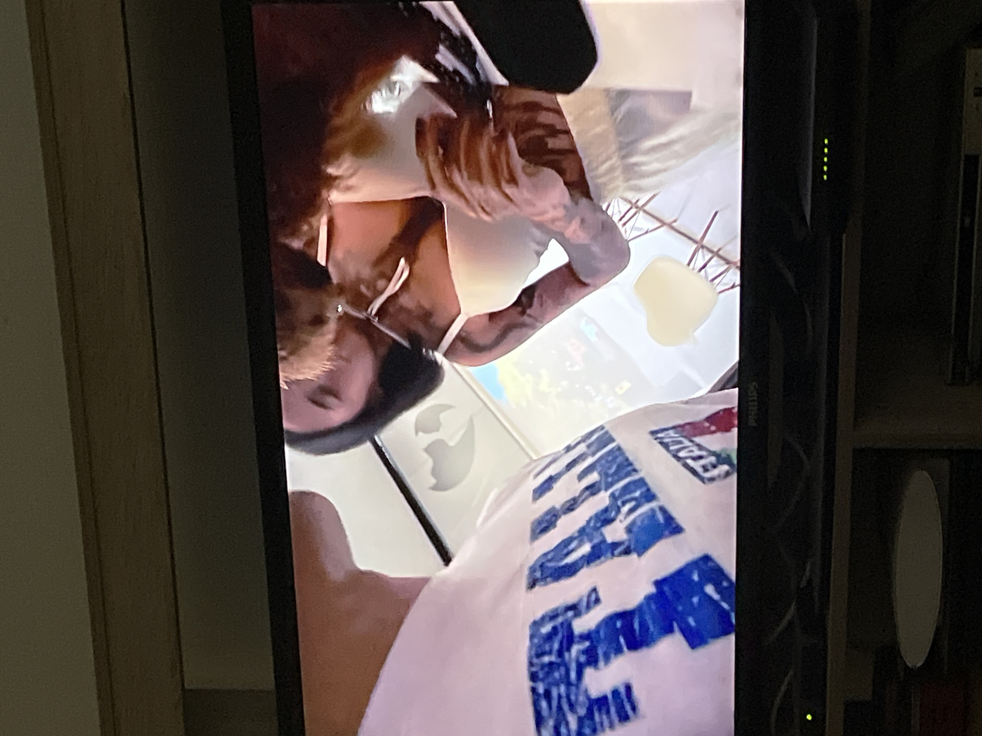 TV screen displaying two people, one in Italia shirt