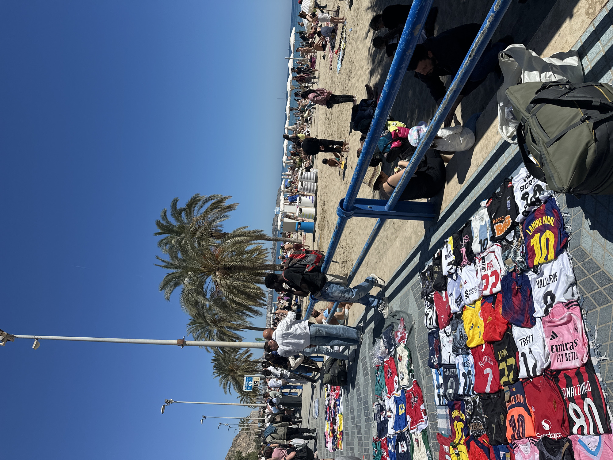 Street vendors sell merchandise on busy Alicante promenade