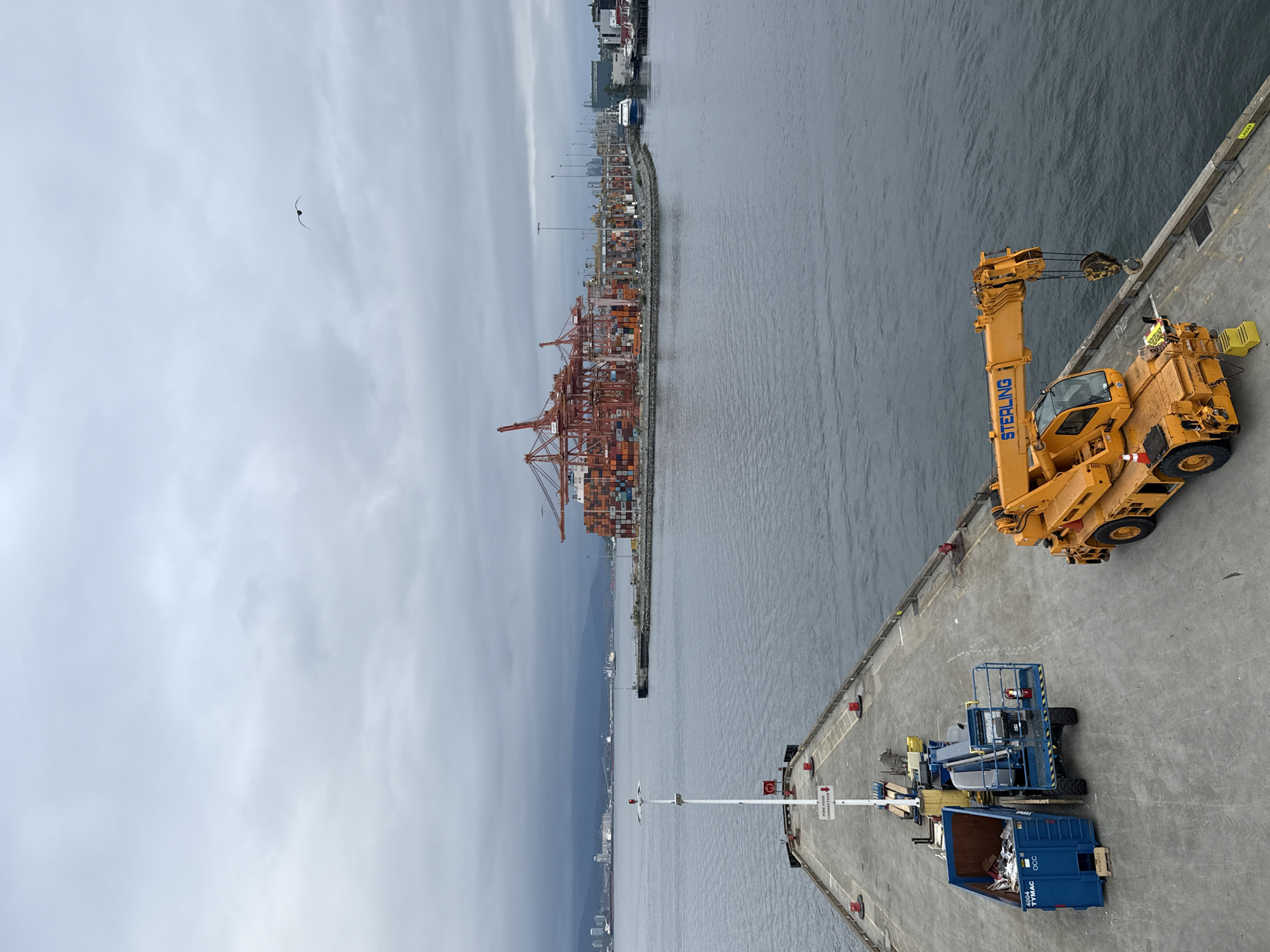 Seaplane departs Vancouver harbor amid industrial port scenery