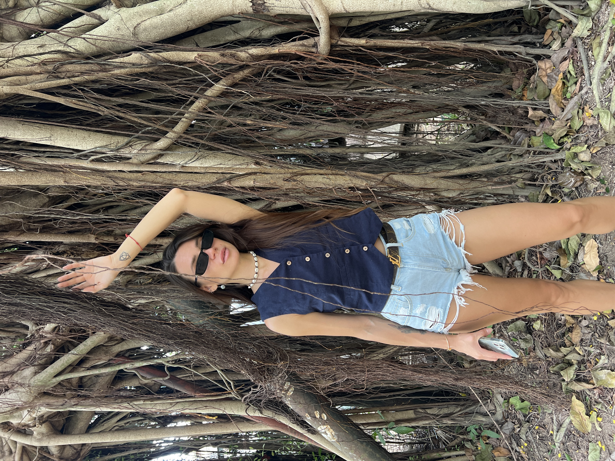Woman explores tropical beach and banyan trees in Thailand