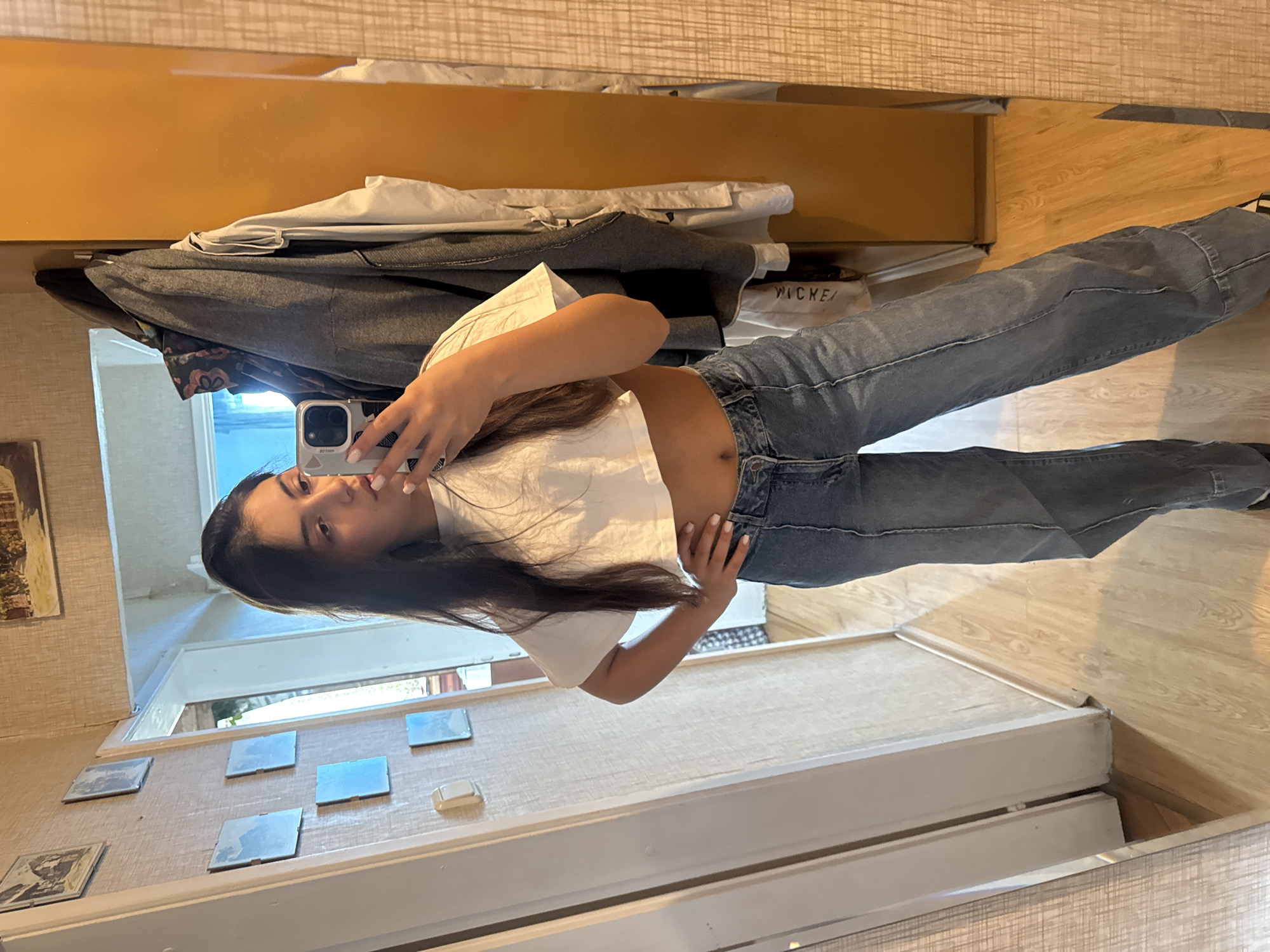 Young woman takes mirror selfie in casual outfit