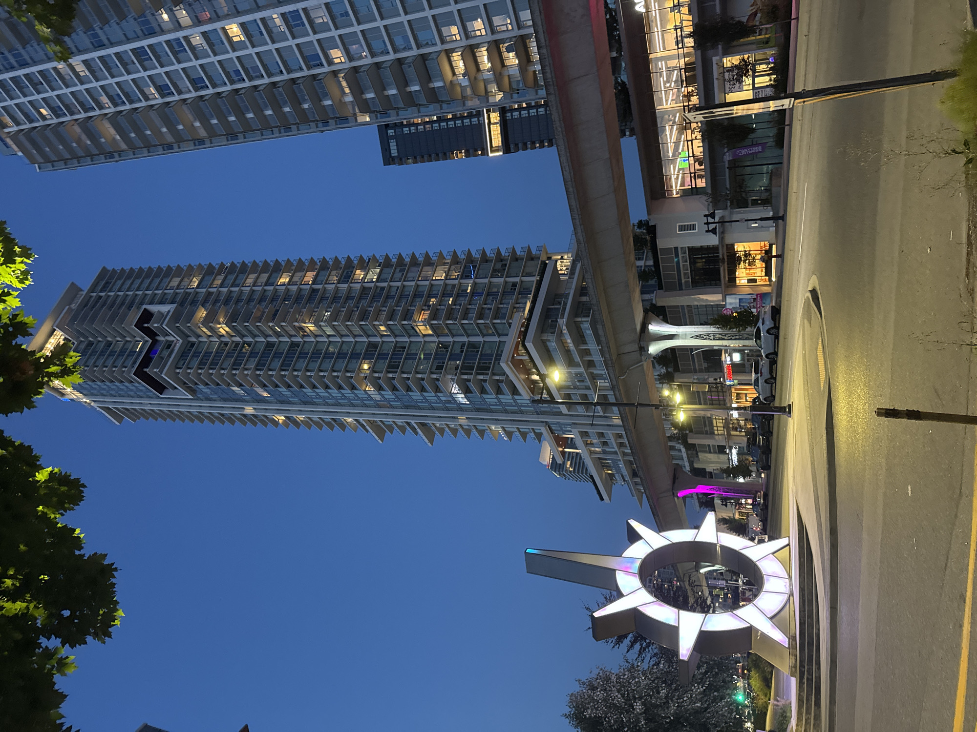 Coquitlam transit corridor at night, towers and SkyTrain overhead