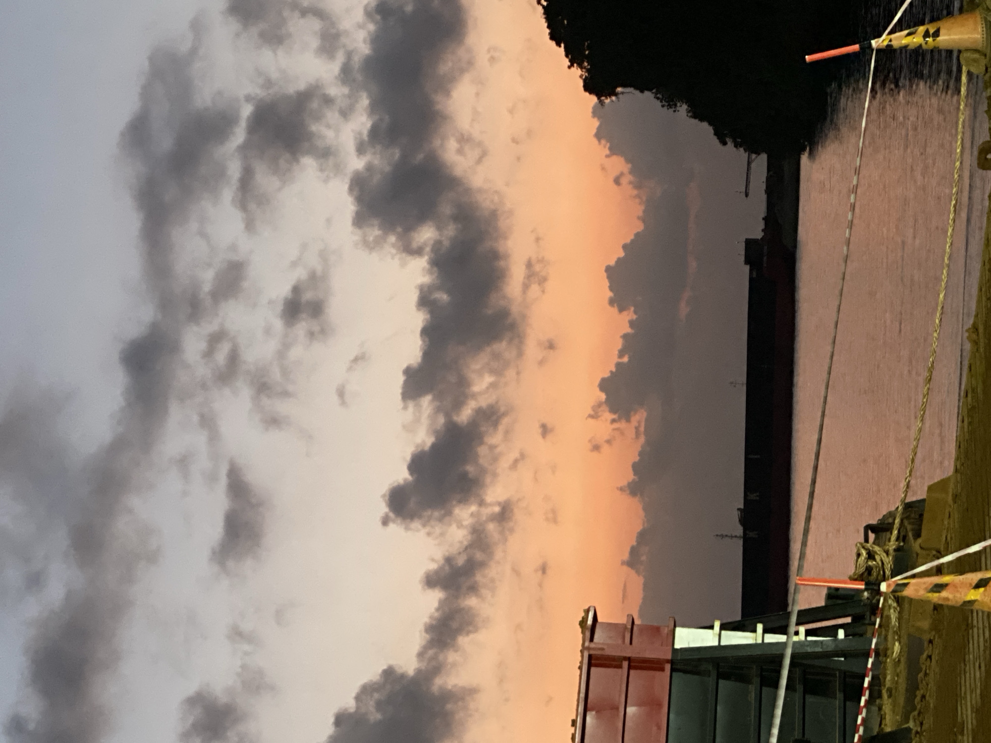 Sambalagi port at dusk: barges, cargo ships, and loading operations