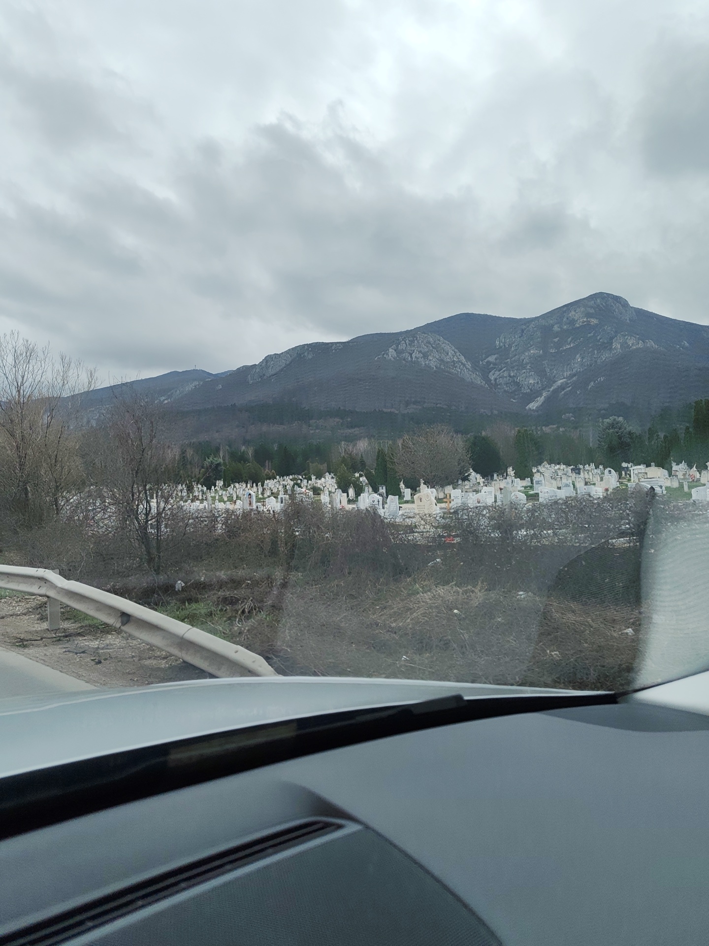 Vehicle drives past cemetery and wet roads in Vratsa